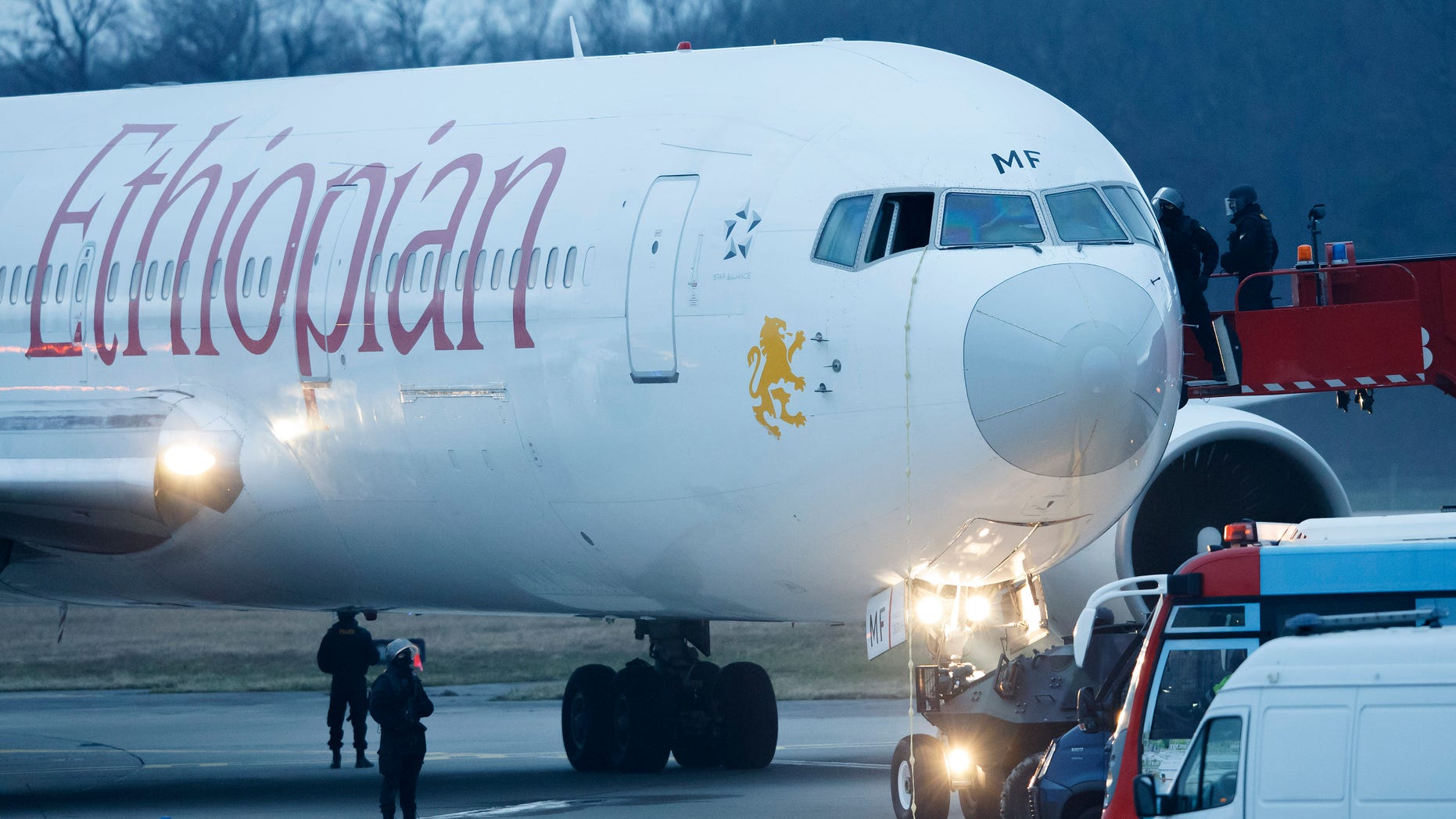 Police stand around the aircraft after passengers were evacuated from a hijacked Ethiopian Airlines Plane on the airport in Geneva, Switzerland, Monday, Feb. 17, 2014. A hijacked aircraft traveling from Addis Abeda, Ethiopia, to Rome, Italy, has landed at Geneva's international airport early Monday morning. Swiss authorities have arrested the hijacker. (AP Photo/Keystone, Salvatore Di Nolfi)