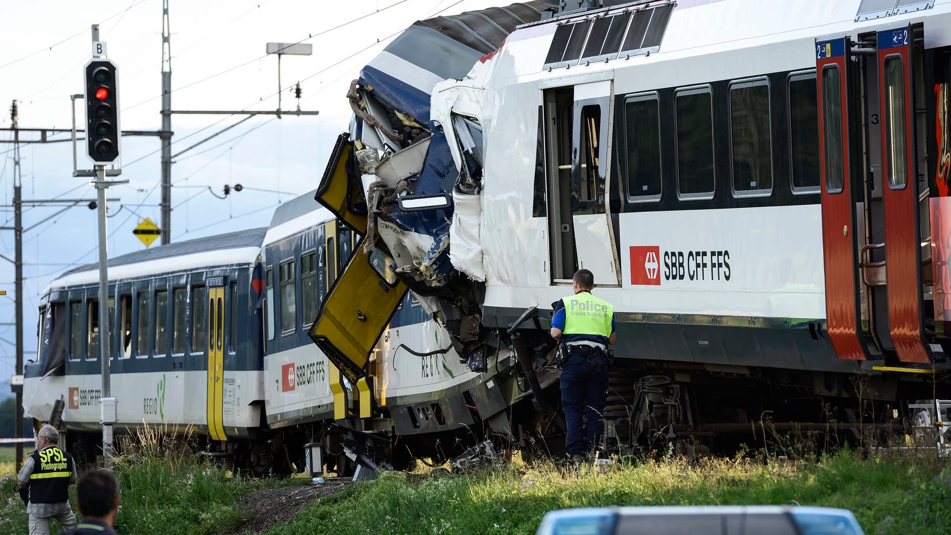 July 29, 2013 - Police inspect the site where two passenger trains collided head-on in Granges-pres-Marnand, western Switzerland. Dozens of people have been injured.