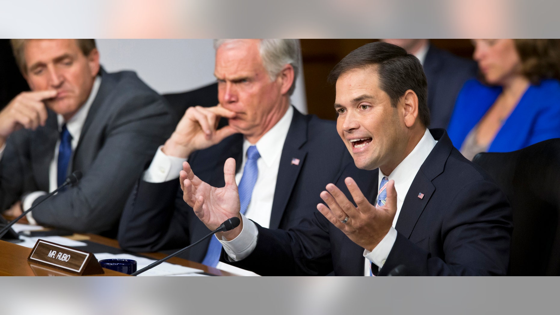 Senate Foreign Relations Committee member Sen. Marco Rubio, R-Fla., joined by fellow committee members, Sen. Ron Johnson, R-Wis., center, and Sen. Jeff Flake, R-Ariz., questions Secretary of State John Kerry during committee's hearing on President Barack Obama's request for congressional authorization for military intervention in Syria, a response to last month's alleged sarin gas attack in the Syrian civil war, Tuesday, Sept. 3, 2013, on Capitol Hill in Washington. (AP Photo/J. Scott Applewhite)