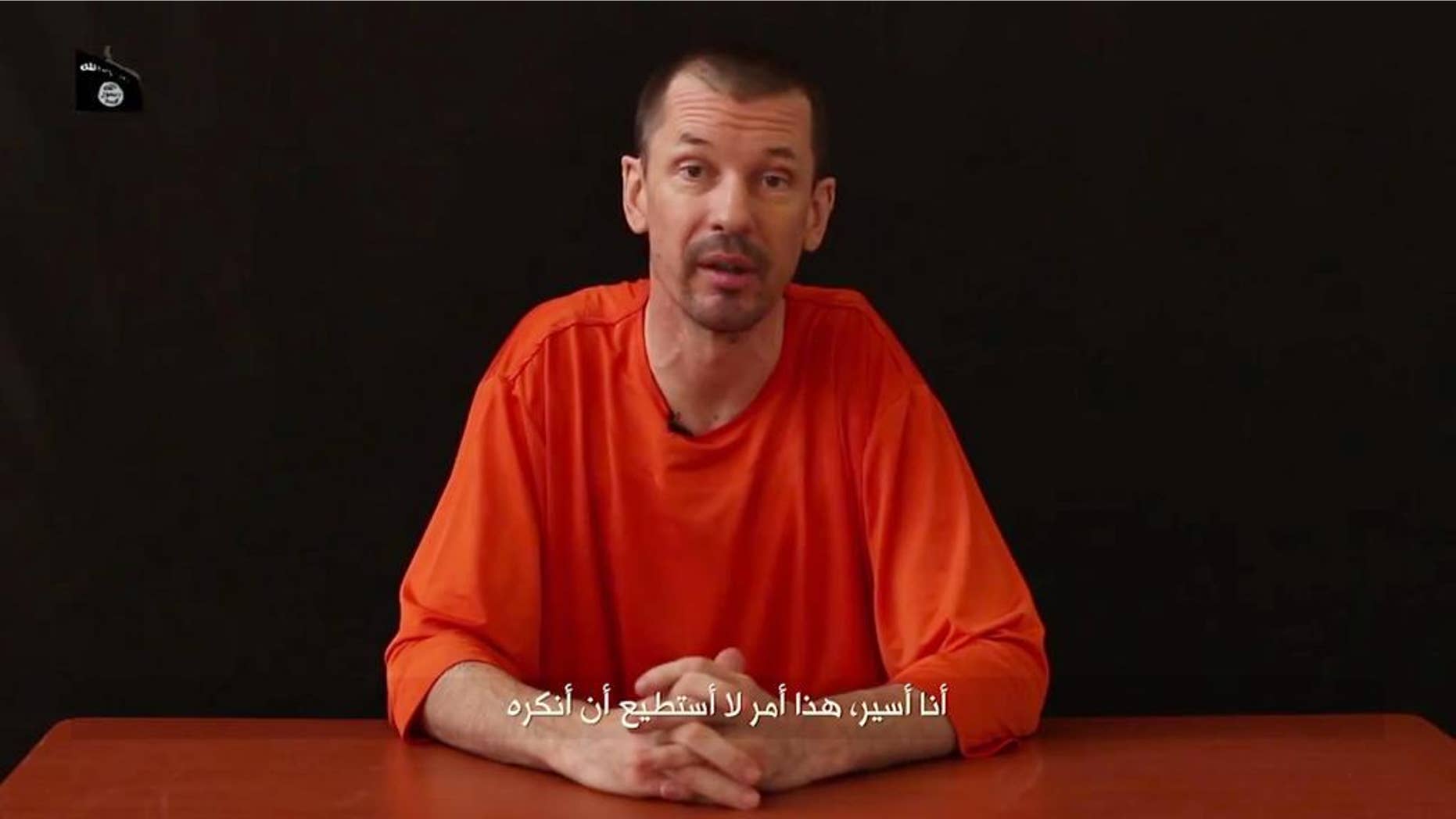 In this still image taken from an undated video published on the Internet by Al-Furqan, the media arm of the Islamic State group militants, captive British journalist John Cantlie speaks into the camera on the first of what he says will be a series of lecture-like "programs" in which he says he will reveal "the truth" about the Islamic State group. The Arabic subtitle reads "I am a prisoner and that is something I will not deny." (AP Photo)