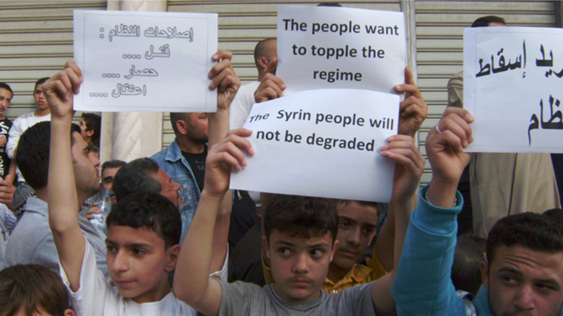 May 5, 2011: In this citizen journalism image made on a mobile phone and acquired by the AP, Syrians carry banners during a protest against the regime of President Assad, in the coastal town of Banias, Syria.
