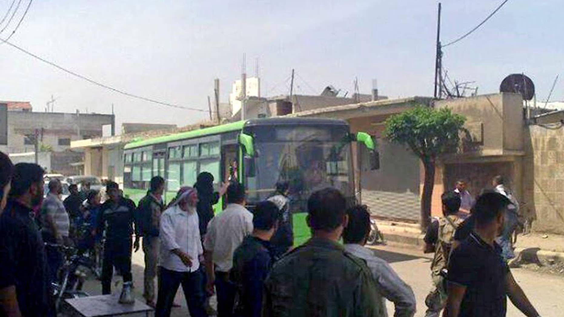 In this Wednesday, May 7, 2014 photo provided by the anti-government activist group Coordination Committee of Khalidiya Neighborhood in Homs, which has been authenticated based on its contents and other AP reporting, Free Syrian Army fighters board a bus leaving Homs, Syria. President Barack Obama may soon sign off on a project to train and equip moderate Syrian rebels, in an open move that would significantly boost U.S. support to forces who have been asking for three years for military help in their quest to oust President Bashar Assad, administration officials said Tuesday.The step, which could be announced as early as Wednesday, would send a limited number of American troops to Jordan to be part of a regional training mission that would instruct carefully vetted members of the Free Syrian Army on tactics, including counterterrorism operations, the officials said. They said Obama has not yet given final approval for the initiative, and that there is still internal discussion about its merits and potential risks. (AP Photo/The Coordination Committee of Khalidiya Neighborhood in Homs)