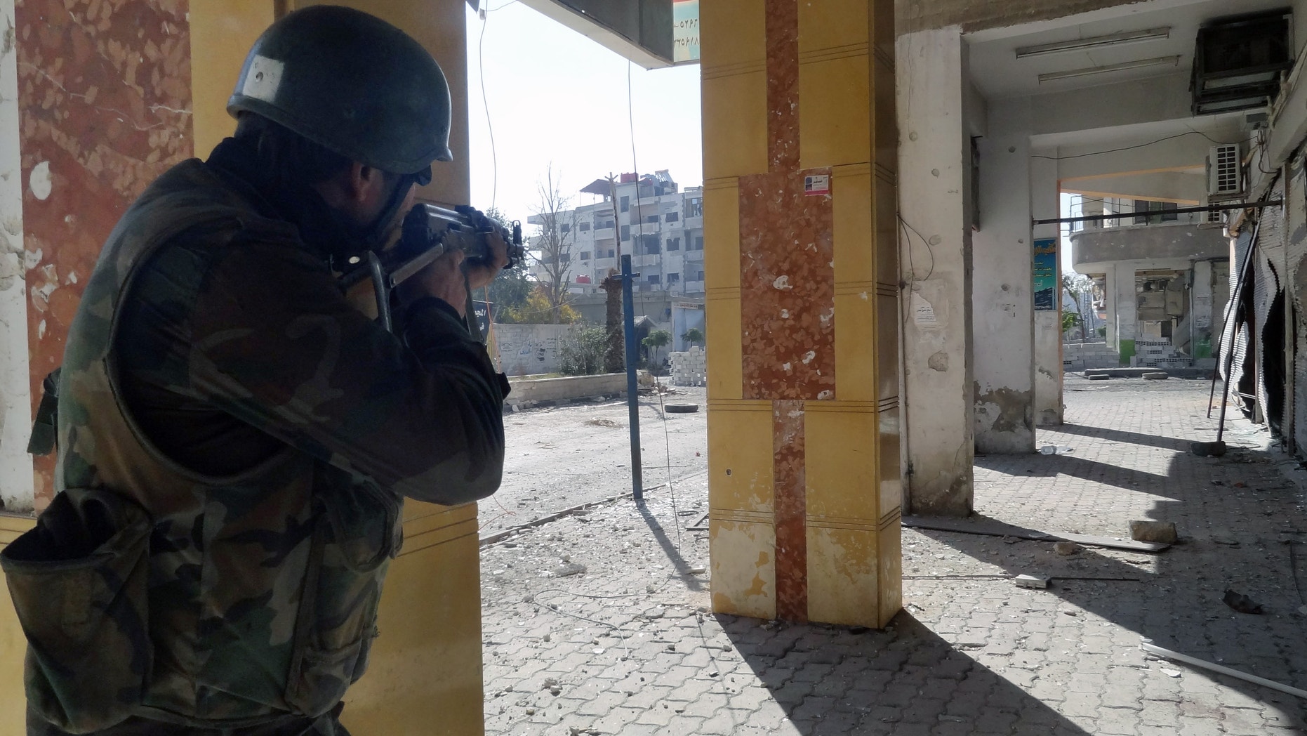 Dec. 2, 2012 Syrian soldier aims his rifle at free Syrian Army fighters during clashes in the Damascus suburb of Daraya, Syria.