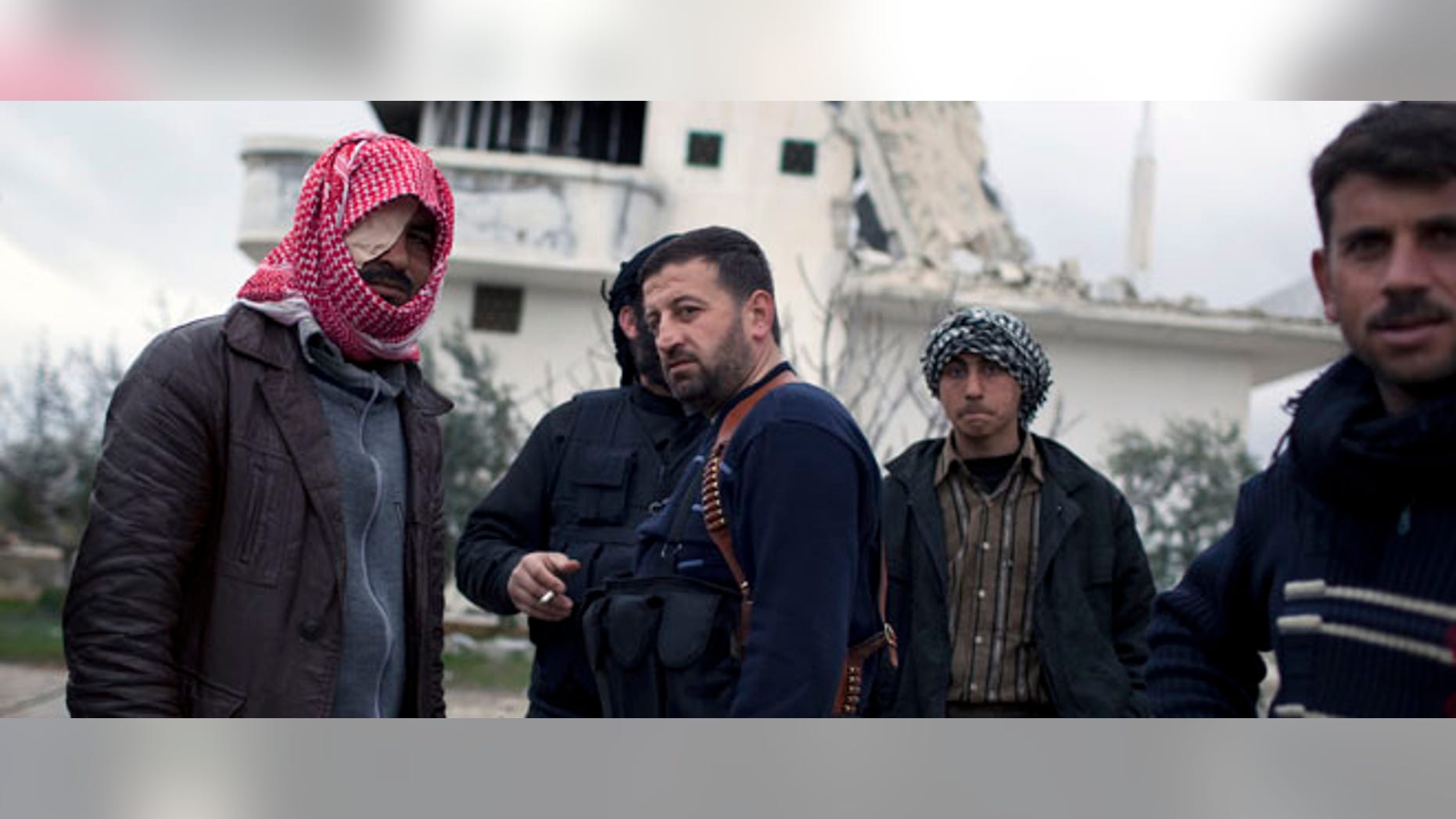 Free Syrian Army soldiers gather outside a house destroyed in fighting against President Assad's forces in Sarmin, north of Syria, Tuesday, Feb. 28, 2012. (AP Photo/Rodrigo Abd)