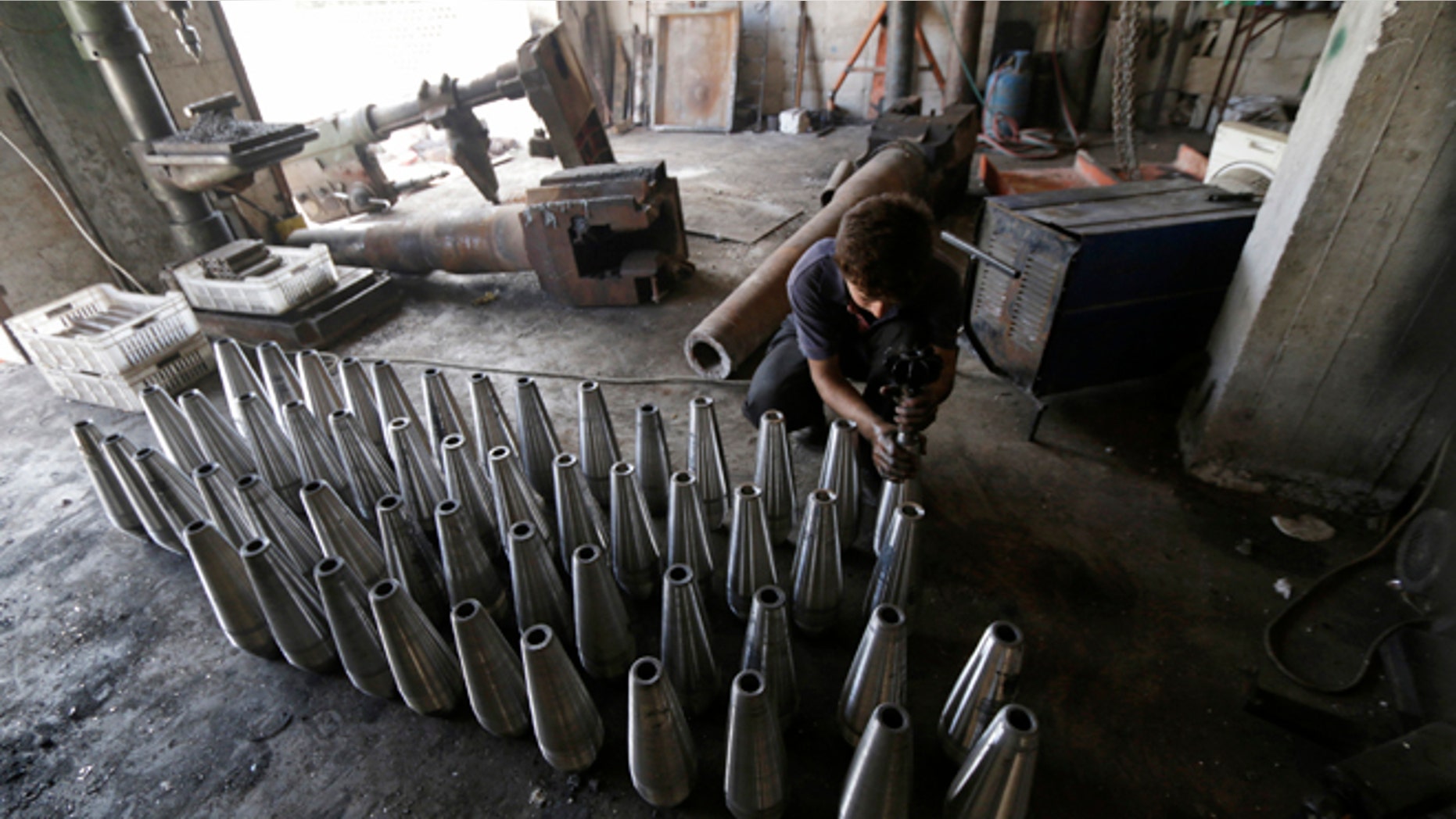 Sept. 9, 2014: A rebel fighter assembles mortar shells inside a weapons factory in the southern countryside of Idlib, Syria.