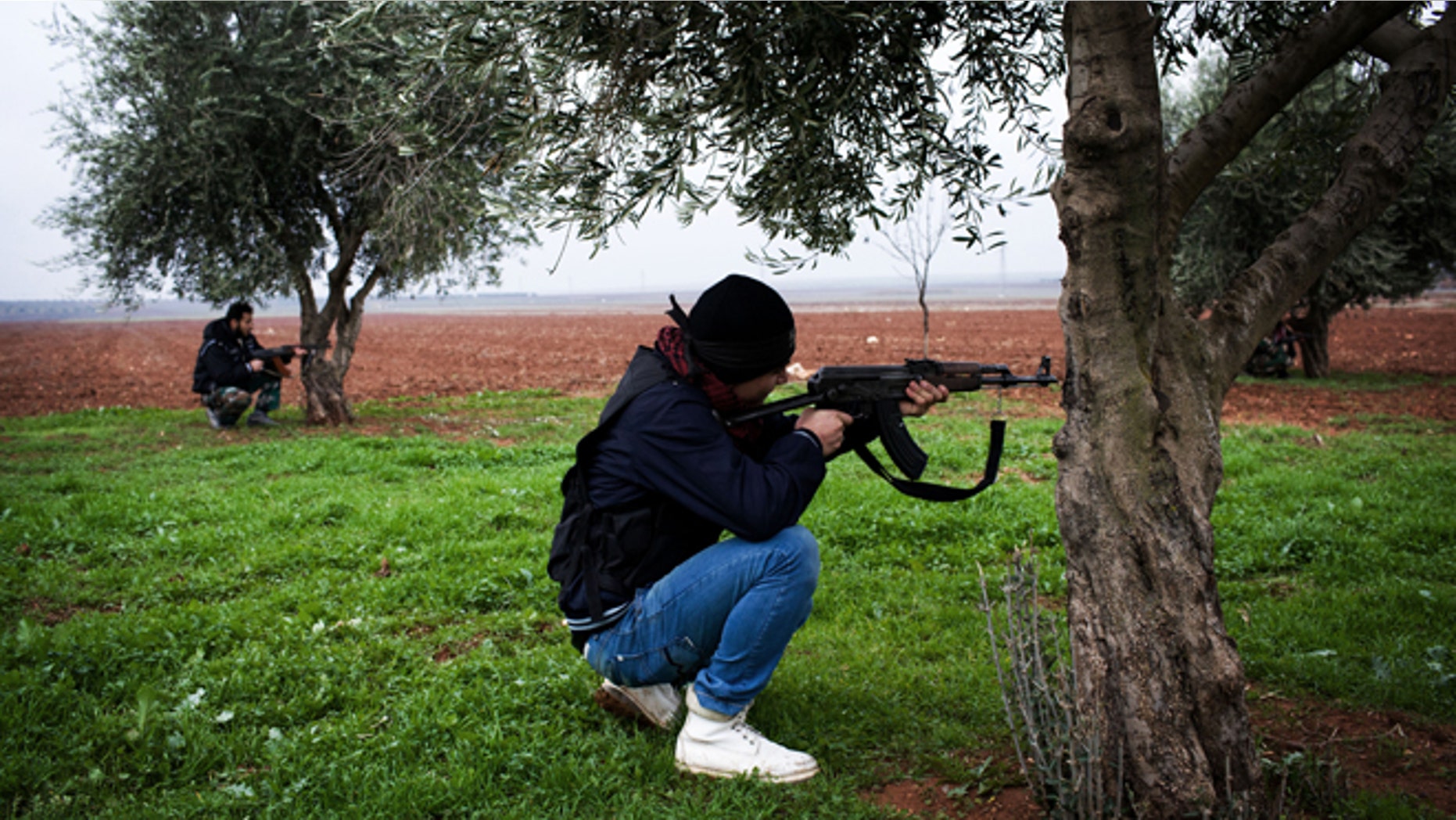 Dec. 10, 2012: Free Syrian Army fighters aim their weapons, close to a military base, near Azaz, Syria.
