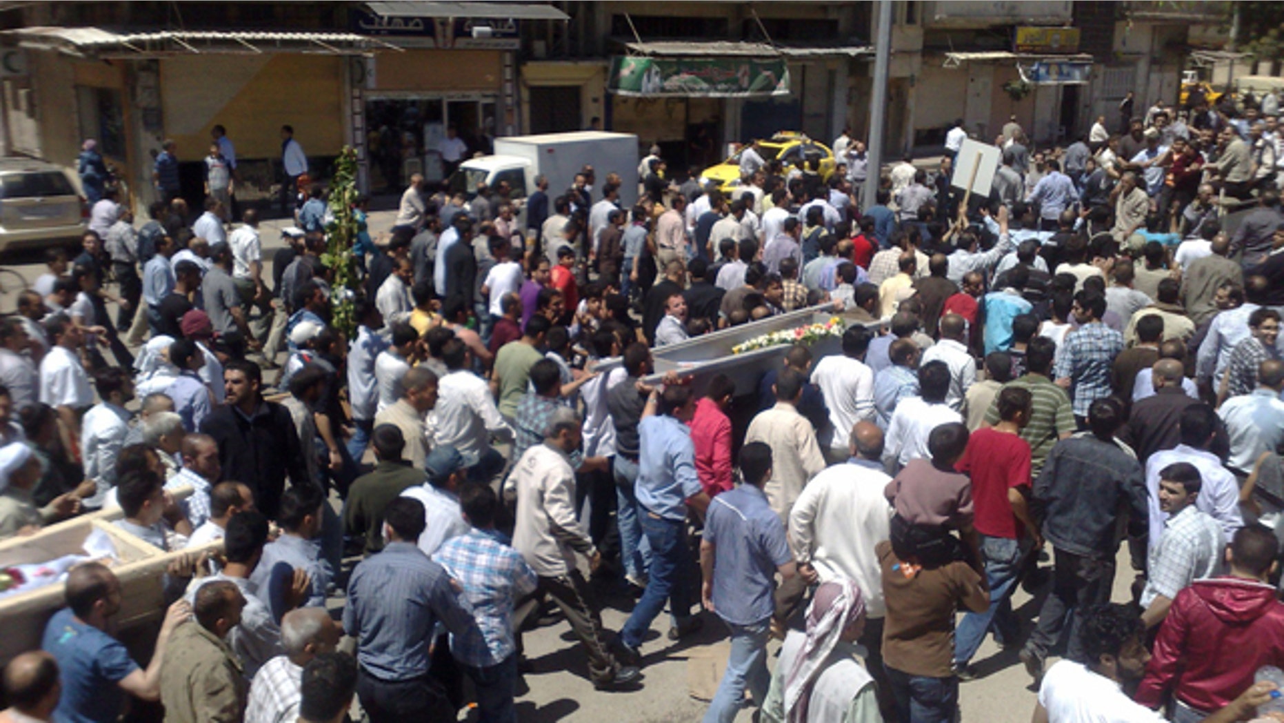 May 21: In this citizen journalism image made on a mobile phone and acquired by the AP Syrian anti-government supporters carry the coffins of people whom they say were killed in the government crackdown, in the central city of Homs, Syria.