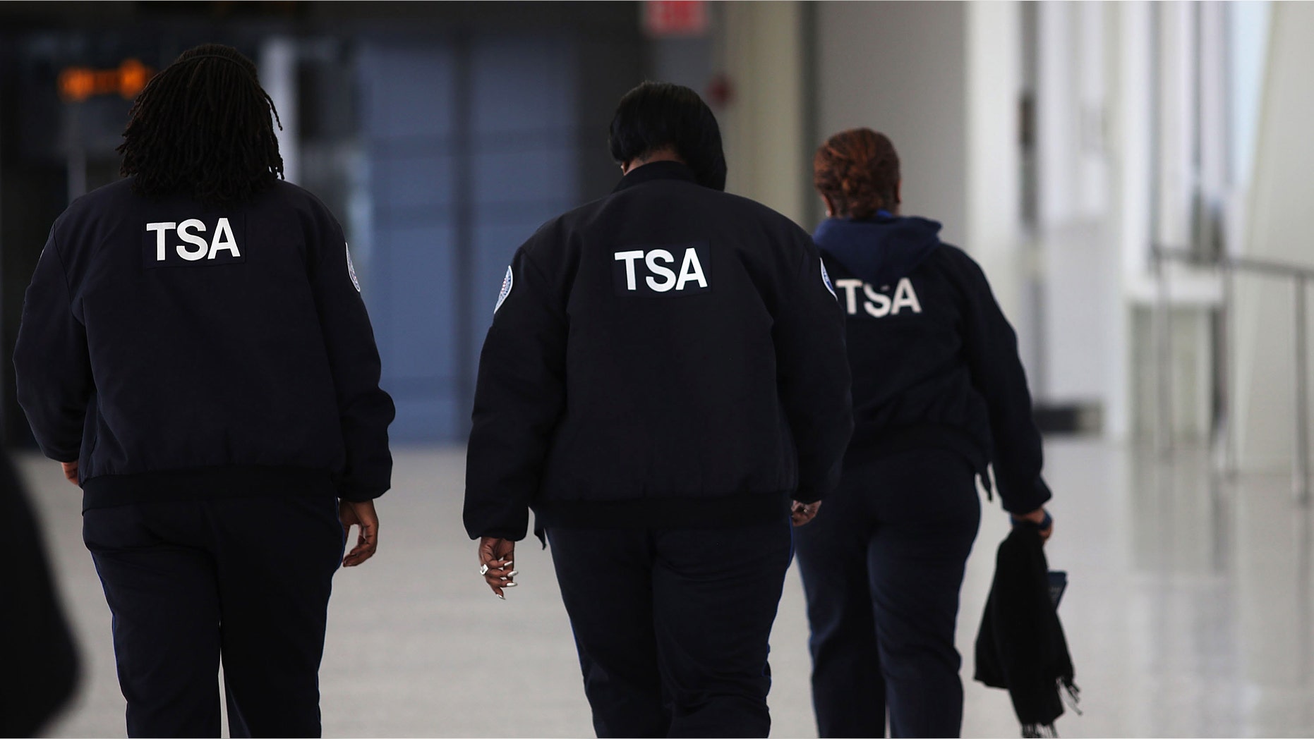 NEW YORK, NY - FEBRUARY 28: Transportation Security Administration (TSA) workers walk through John F. Kennedy Airport on February 28, 2013 in New York City. Should the $85 billion in automatic federal budget cuts, known as the sequester, go into effect Friday as scheduled, airport control towers in a number of states could close, putting pilots and staff members at risk. In addition to the closed control towers, TSA workers could be furloughed, leading to long waits and confusion at many airport security checkpoints. (Photo by Spencer Platt/Getty Images)