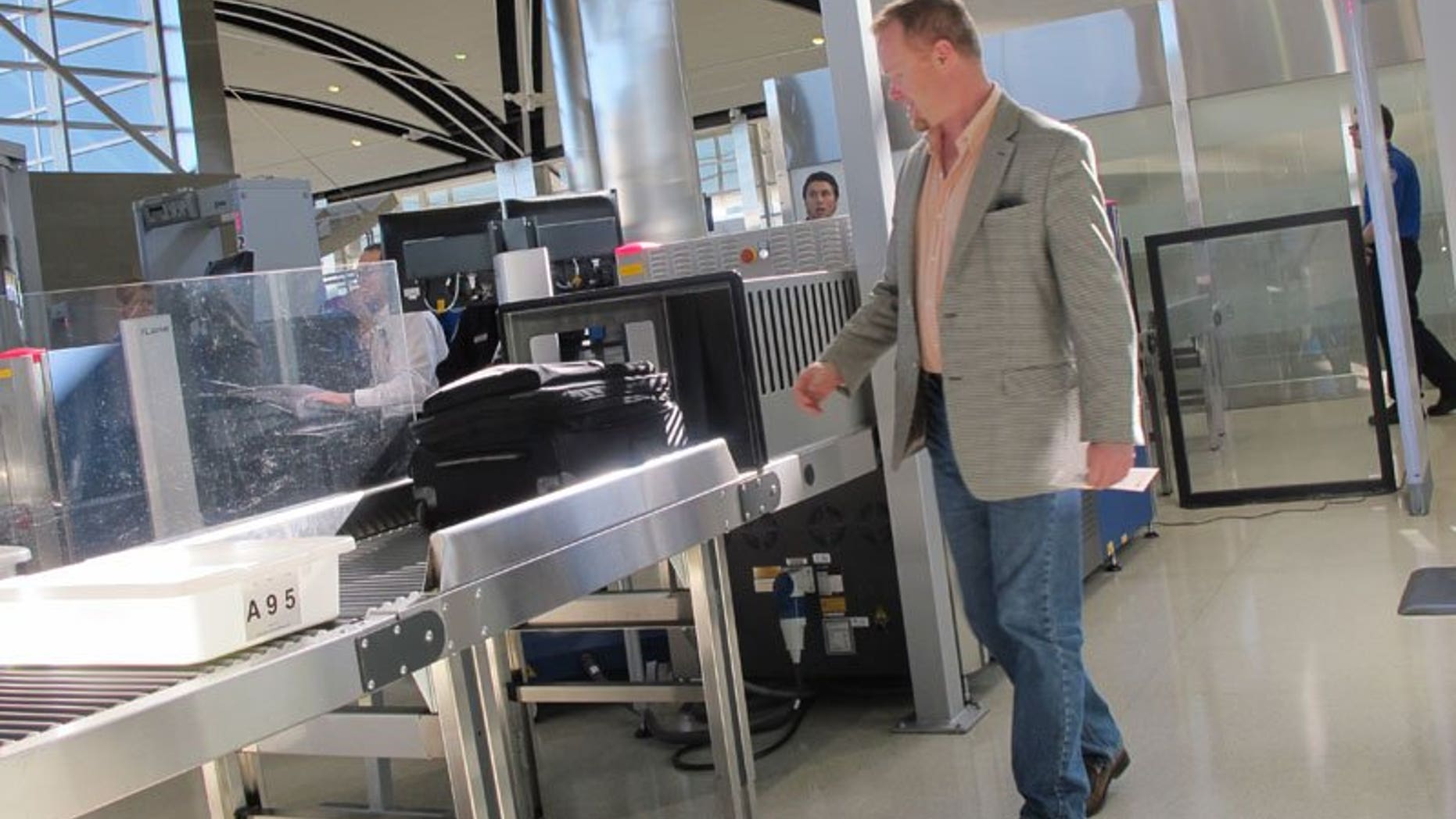 October 4: Mark Daly of Novi, Michigan, passes through the new expedited screening line at Detroit Metro Airport in its first hours of operation.