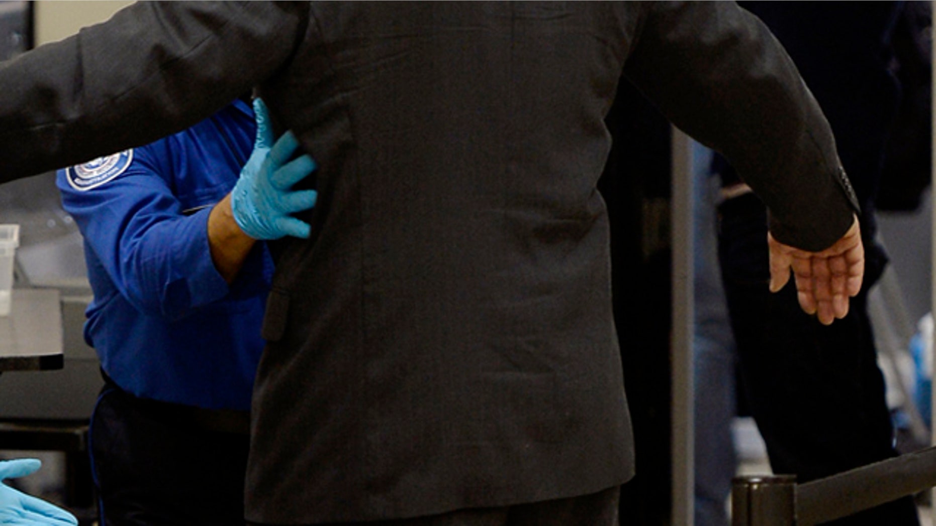 An airline passenger is patted down by a Transportation Security Administration agent after passing through a full-body scanner at Los Angeles International Airport.