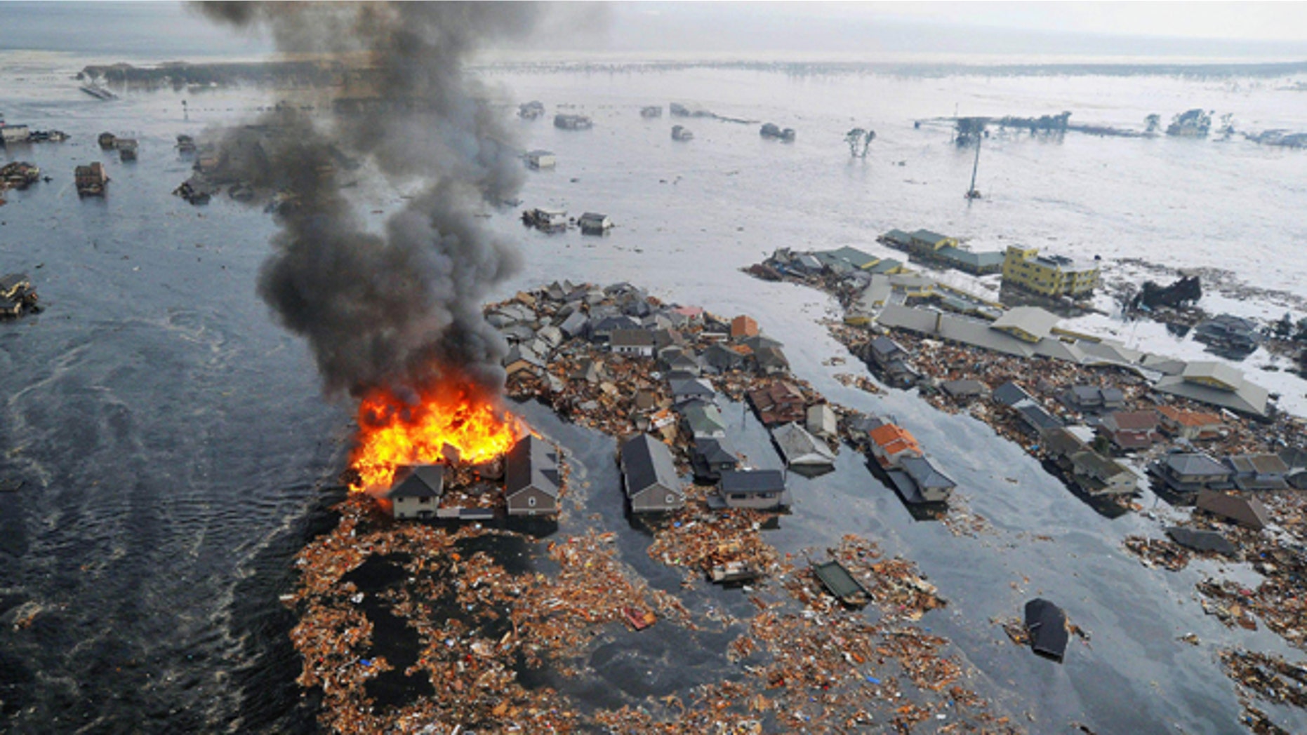 March 11: Houses swallowed by tsunami waves burn in Sendai, Miyagi Prefecture (state) after Japan was struck by a strong earthquake off its northeastern coast.