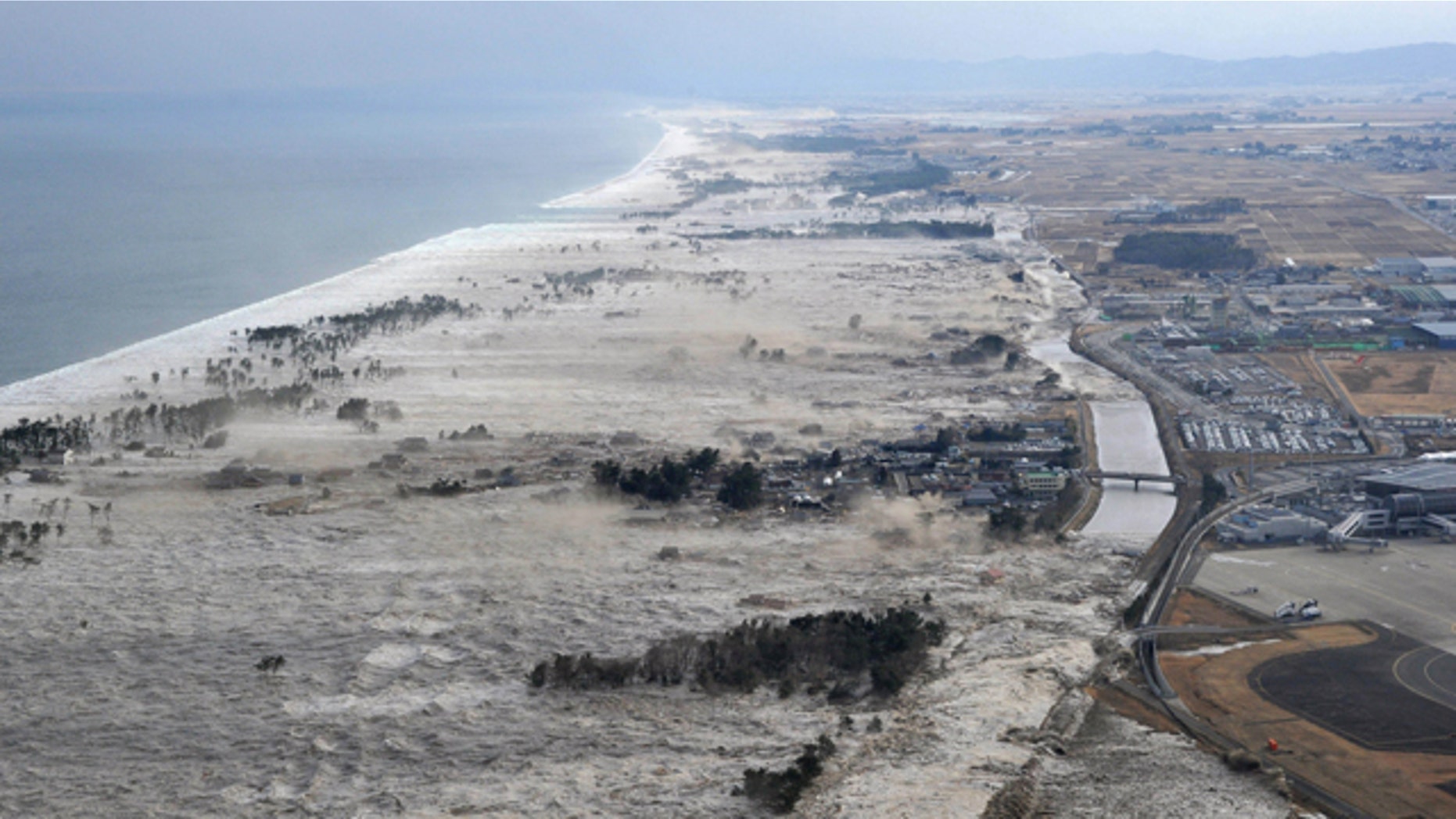 March 11: Earthquake-triggered tsumanis sweep shores along Iwanuma in northern Japan.