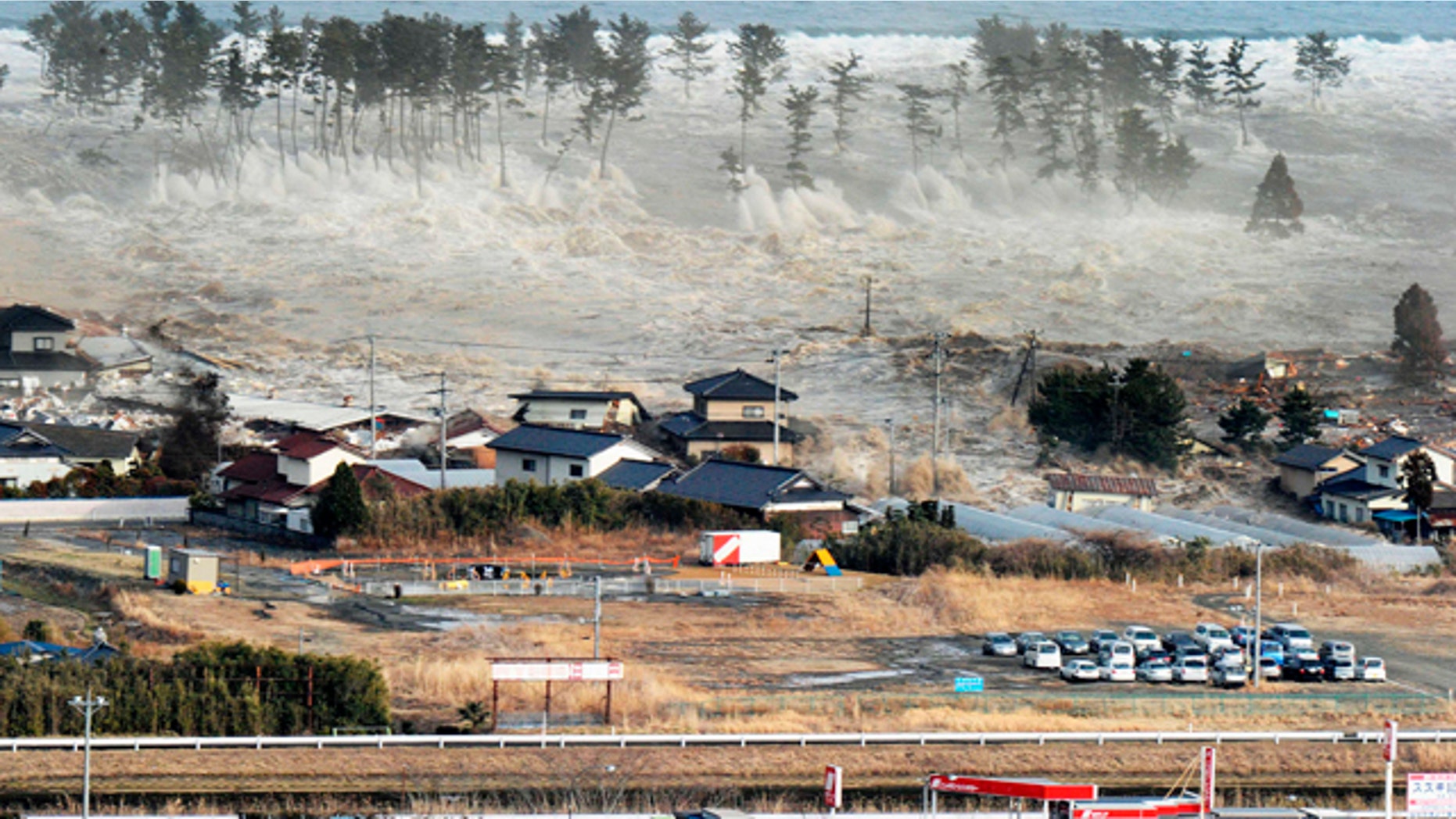 March 11: Waves of tsunami hit residences after a powerful earthquake in Natori, Miyagi prefecture.
