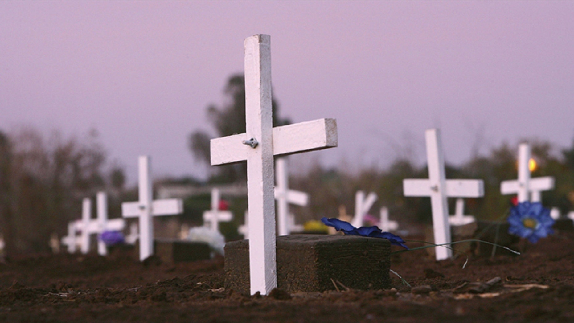 CALEXICO, CA - FEBRUARY 02: Grave marker crosses are seen in the night after activists on the "March for Migrants" placed them on the graves of approximately 400 people in a cemetery plot set aside for unidentified people who died trying to cross illegally into the US from Mexico on the anniversary of the signing of the treaty of Guadalupe-Hidalgo on February 2, 2006 in Holtville near the border town of Calexico, California. Among a host of issues that the "March for Migrants" caravan is pushing are opposition to HR 4437 bill to beef up border operations, demand for action in the case of Guillermo Martinez Rodriguez who was allegedly killed by US Border Patrol agents, and to bring attention to some 4000 migrants who have died since the inception of Operation Gatekeeper in 1994 to increase border patrols, according to the group. The activists will travel throughout much of the West and along the US/Mexico border ending in Washington D.C. with three days of rallies and visits to legislators starting February 18. (Photo by David McNew/Getty Images)