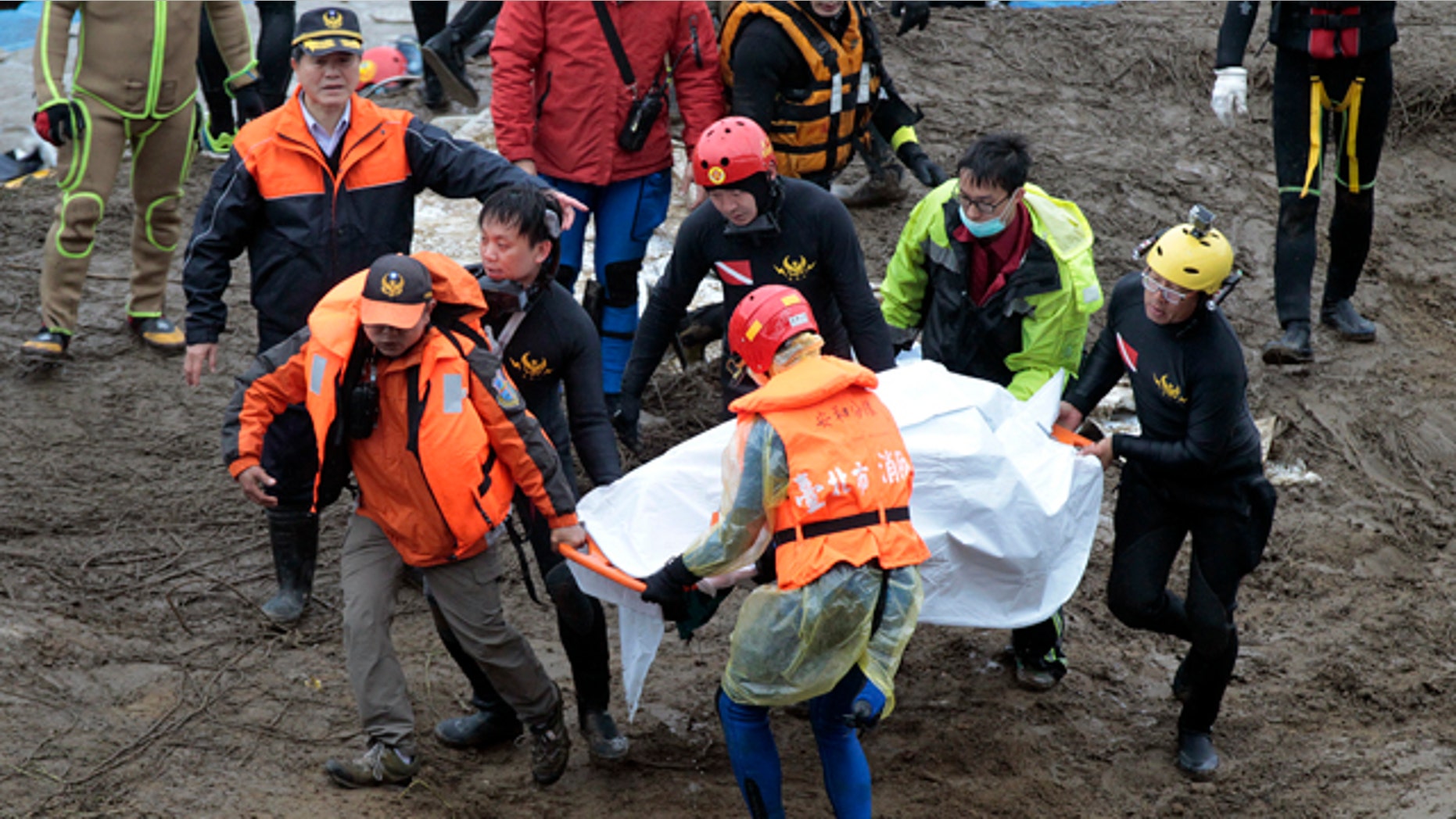 Feb. 6, 2015: Search and rescue divers carry a recovered body at the site of a commercial plane crash in Taipei, Taiwan. TransAsia Airways Flight 235 with 58 people aboard clipped a bridge shortly after takeoff and crashed into a river in the island's capital of Taipei on Wednesday morning. (AP Photo/Wally Santana)