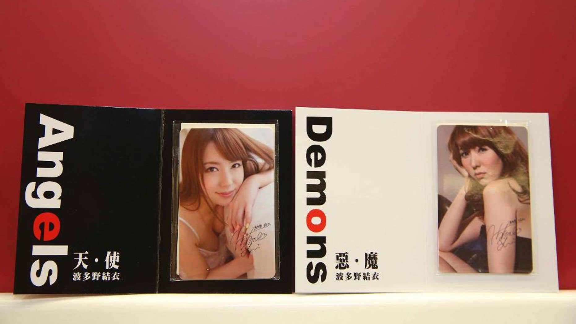 In this photo taken on Aug. 26, 2015, by the Central News Agency, two special edition swipe cards for Taiwan's mass transit are seen on display featuring the clothed image of 27-year-old, Japanese porn star Yui Hatano, in Taipei, Taiwan. Despite strong opposition, the 15,000 limited-edition cards sold out within hours overnight via a telephone hotline. (Central News Agency via the AP)