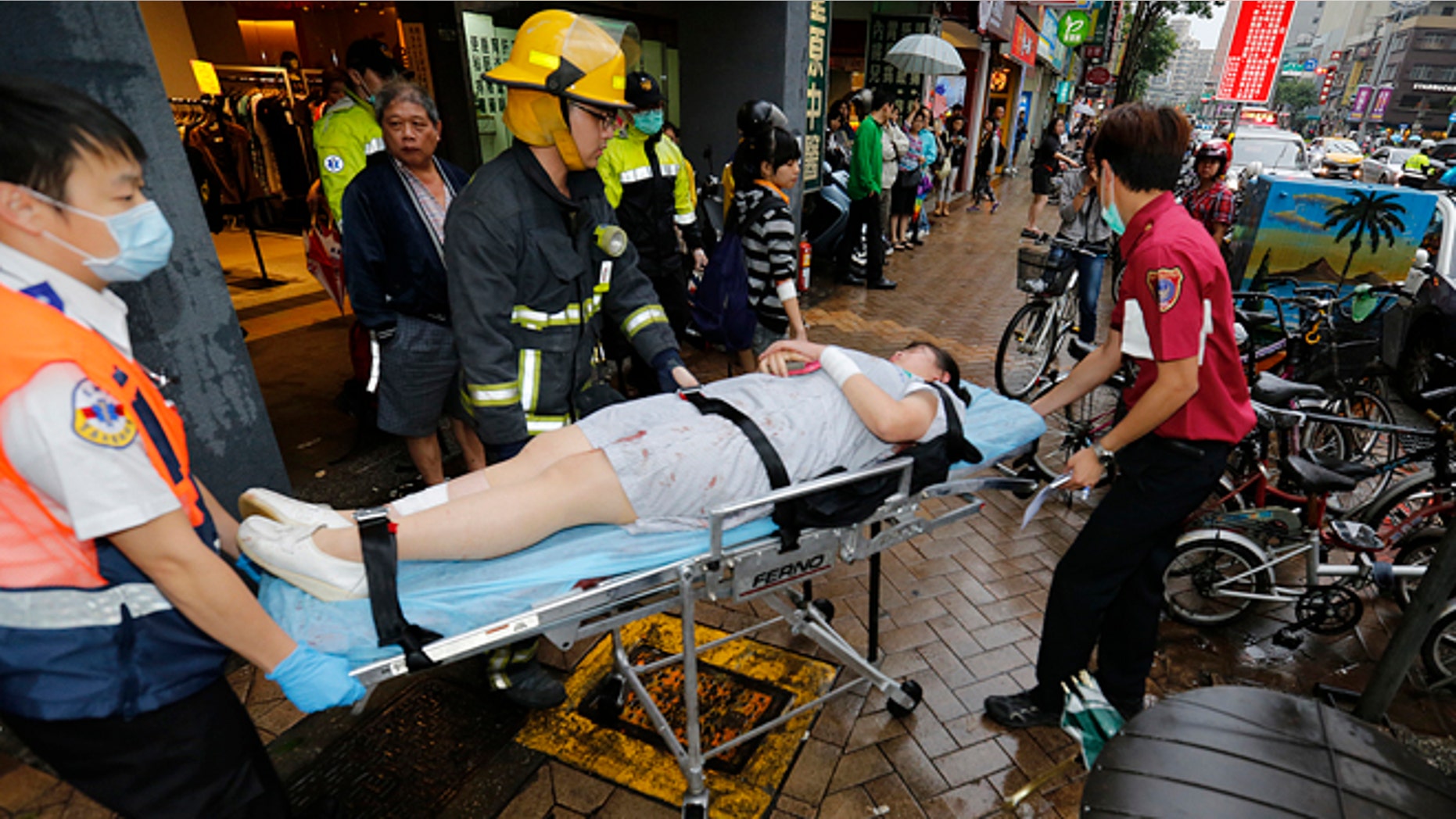 May 21, 2014: Paramedics remove a victim from a subway station exit after a knife attack on a subway in Taipei, Taiwan. (AP)