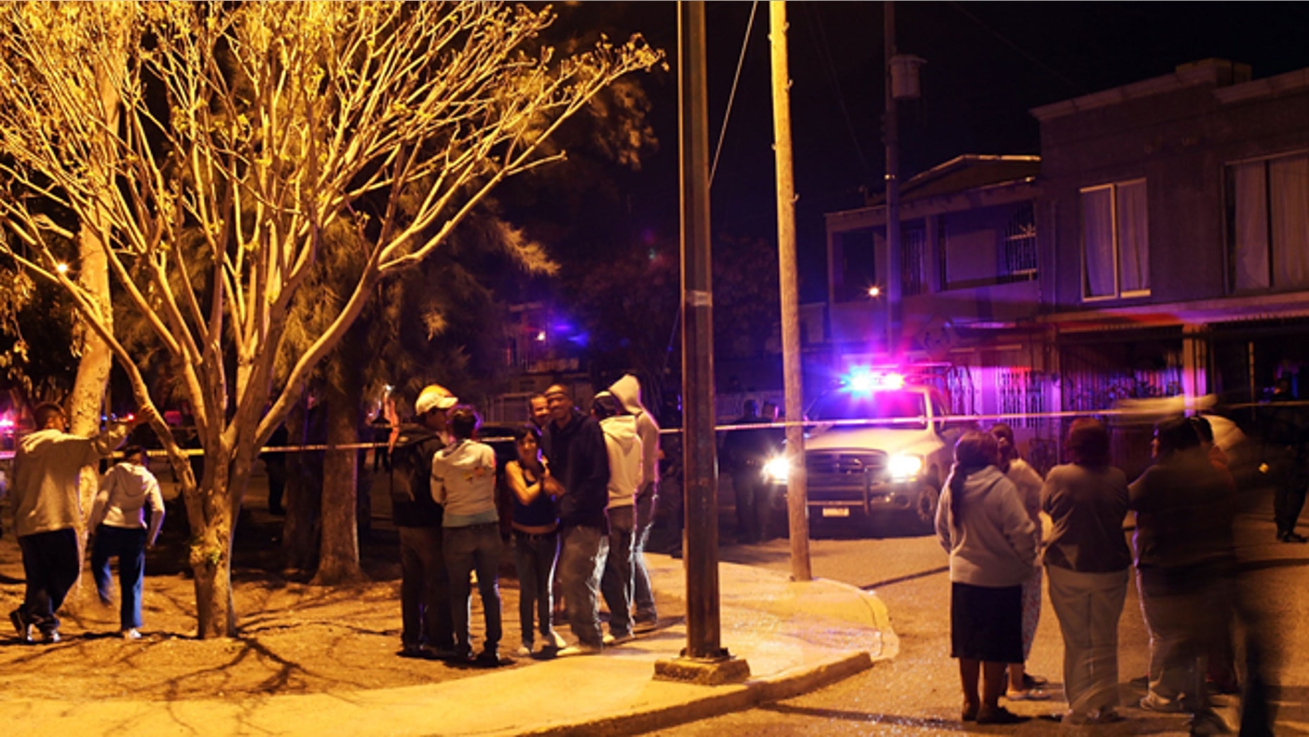 JUAREZ, MEXICO - MARCH 25: Residents look out at a crime scene involving the killing of a 13 year old boy in a car, one of numerous murders over a 24 hour period, on March 25, 2010 in Juarez, Mexico. Secretary of State Hillary Rodham Clinton, Defense Secretary Robert Gates, and Homeland Security Secretary Janet Napolitano all visited Mexico on March 23 for discussions centered on Mexico's endemic drug-related violence. The border city of Juarez, Mexico has been racked by violent drug related crime recently and has quickly become one of the most dangerous cities in the world to live. As drug cartels have been fighting over ever lucrative drug corridors along the United States border, the murder rate in Juarez has risen to 173 slayings for every 100,000 residents. President Felipe Calderon's strategy of sending 7000 troops to Juarez has not mitigated the situation. With a population of 1.3 million, 2,600 people died in drug-related violence last year and 500 so far this year, including two Americans recently who worked for the U.S. Consulate and were killed as they returned from a children's party. (Photo by Spencer Platt/Getty Images)