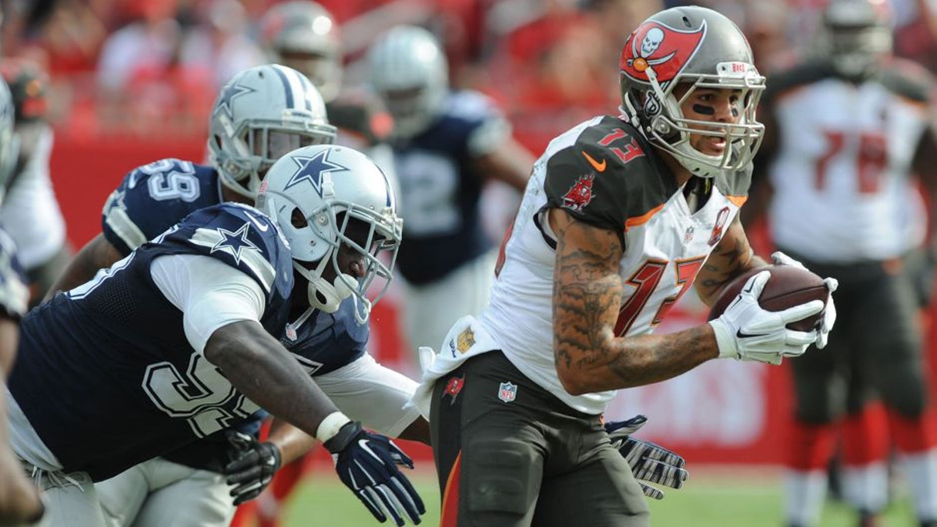 TAMPA, FL - NOVEMBER 15: Wide receiver Mike Evans #13 of the Tampa Bay Buccaneers runs after the catch past defensive tackle David Irving #95 of the Dallas Cowboys in the second quarter at Raymond James Stadium on November 15, 2015 in Tampa, Florida. (Photo by Cliff McBride/Getty Images)