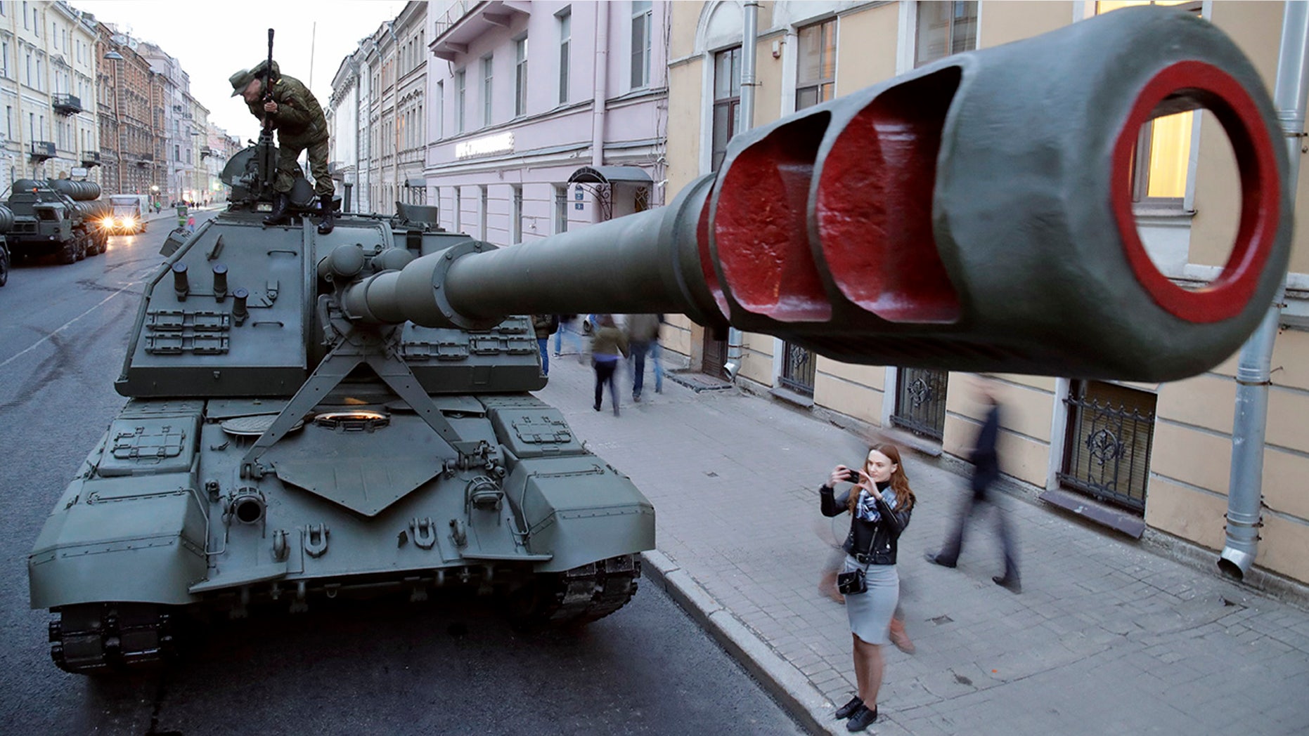 A woman takes a photo of the Self-propelled artillery vehicle Msta S prior to a rehearsal for the Victory Day military parade which will take place at Dvortsovaya (Palace) Square on May 9 to celebrate 73 years after the victory in WWII, in St.Petersburg, Russia, Monday, April 30, 2018. (AP Photo/Dmitri Lovetsky)