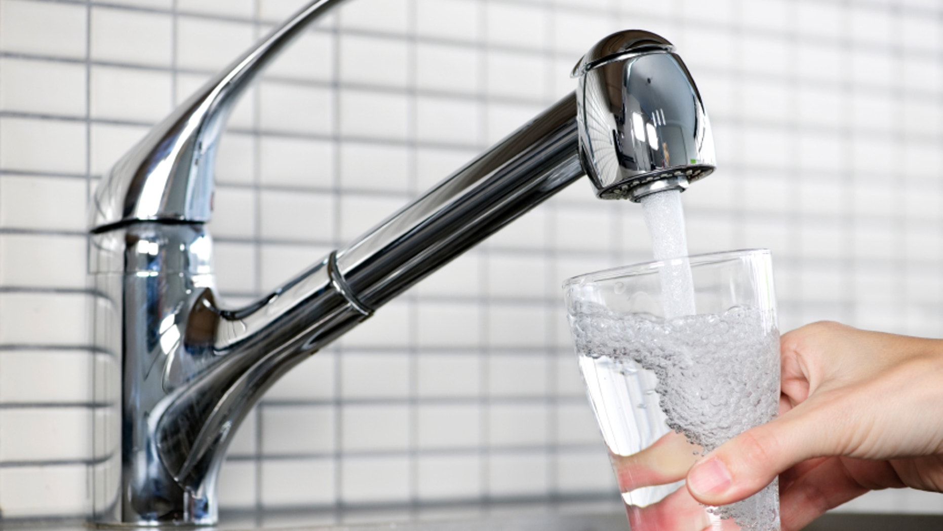 Filling glass of water from stainless steel kitchen faucet