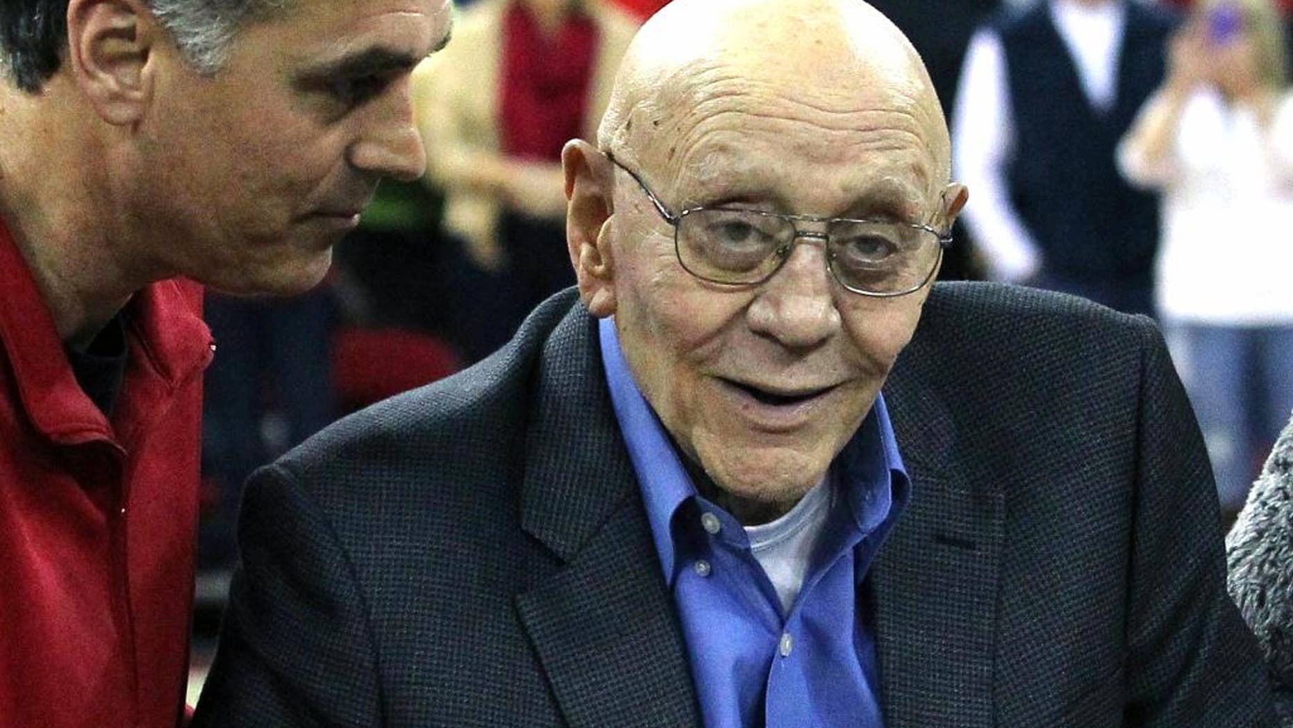 FILE - In this March 1, 2014, file photo, Jerry Tarkanian is escorted by his son, Danny, during halftime ceremonies honoring the former basketball coach at Fresno State University in Fresno, Calif. The Hall of Fame basketball coach is hospitalized in Las Vegas, where his son says he’s being treated for pneumonia. (AP Photo/Gary Kazanjian, File)