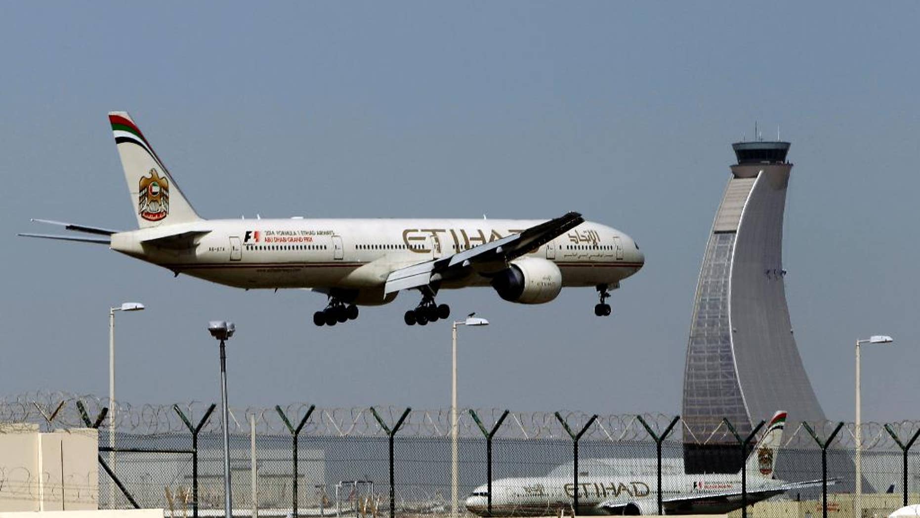 FILE - In this May 4, 2014 file photo, an Etihad Airways plane prepares to land at the Abu Dhabi airport in the United Arab Emirates. Hundreds of air travelers landed in San Francisco Saturday evening, Jan. 3, 2015, safe but irritated after a 28-hour Etihad overseas flight they say included 12 hours on a tarmac at the Abu Dhabi airport without food or accurate flight information. (AP Photo/Kamran Jebreili, File)
