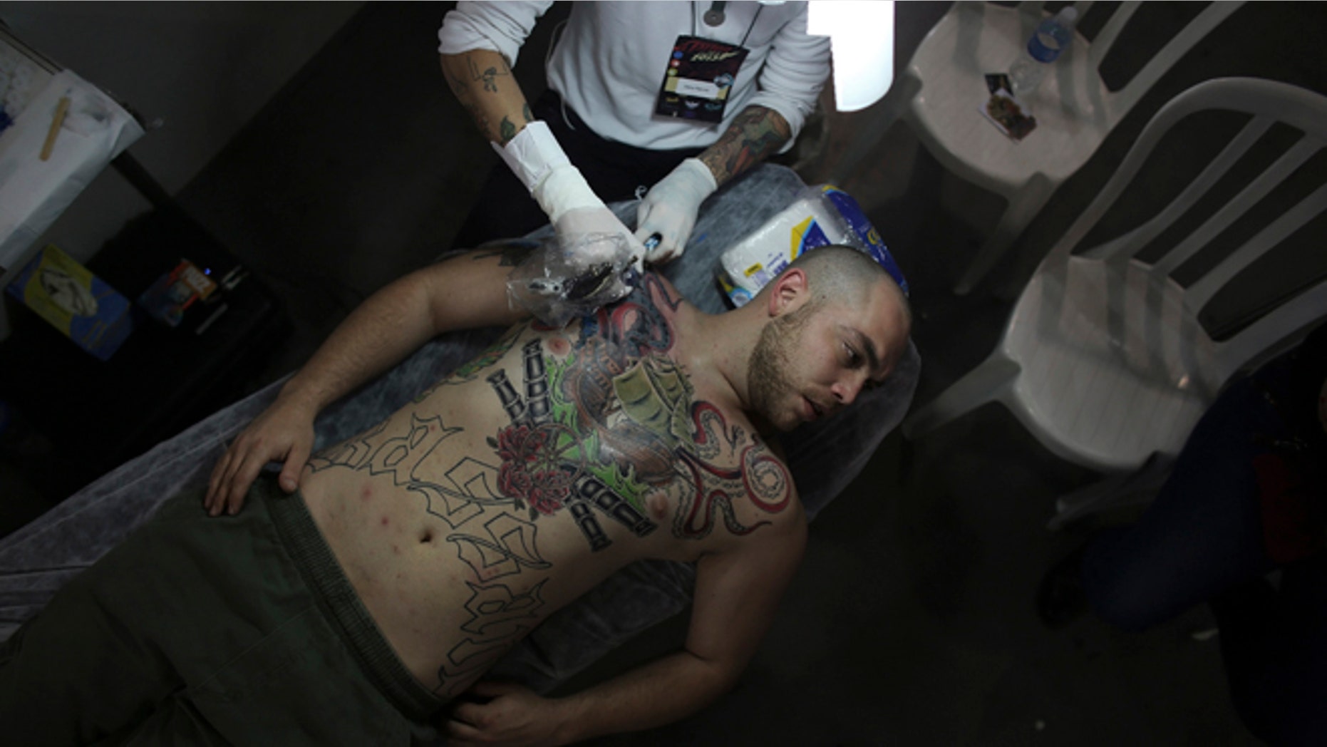 July 20, 2013: An artist works on a tattoo on the body of a man.