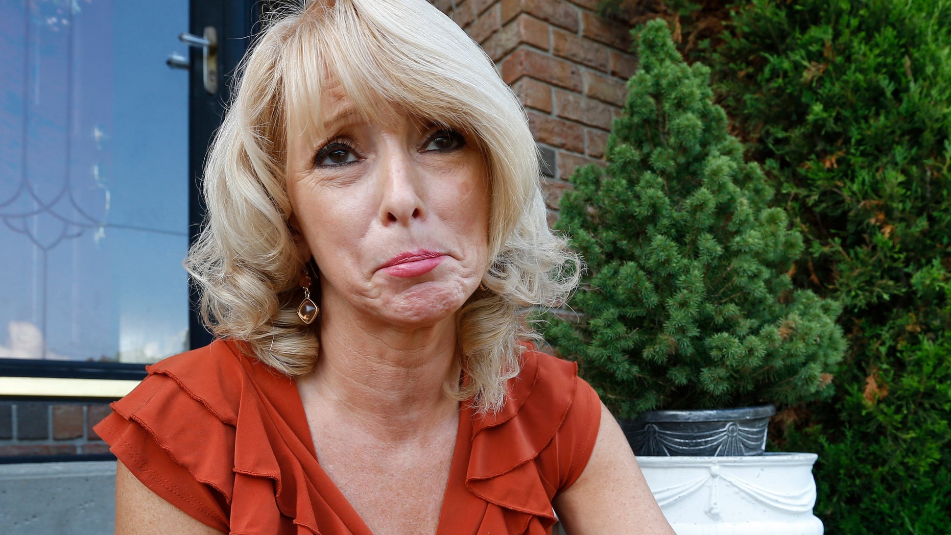 FILE: Eileen Battisti sits on the stairs in front of her home in Aliquippa, Pa.