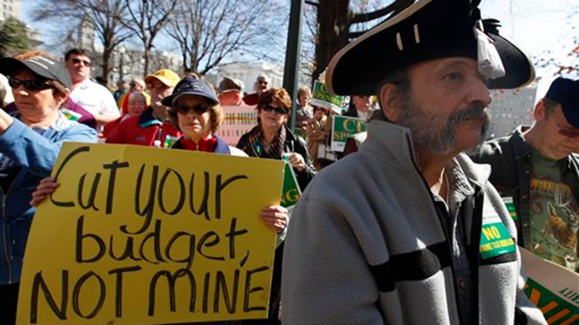 FILE - In this March 8, 2010 file photo, Tea Party member Greg Hernandez, of Quicksburg, Va., wearing a tri-corner hat and tea bag, listens to speakers during a rally at the Capitol in Richmond, Va. (AP Photo/Steve Helber/file)