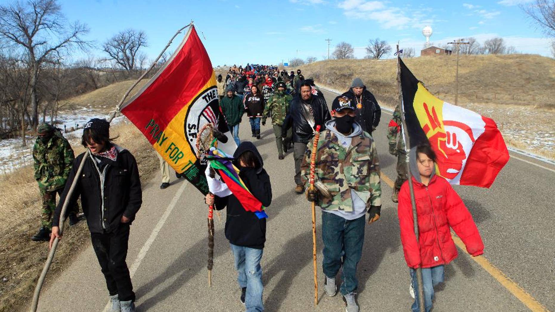 In this Feb. 27, 2014 photo, more than 100 people walk to Wounded Knee during the liberation anniversary of the famous massacre on the Pine Ridge Indian Reservation in South Dakota. Somewhere between 16,000 and 30,000 members of the Oglala Sioux Tribe live on the reservation which includes the county with the highest poverty rate in the U.S., and some of the worst rates of alcoholism and drug abuse, violence and unemployment. (AP Photo/Rapid City Journal, Chris Huber)