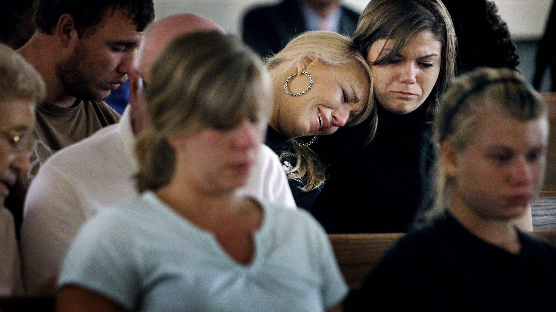 August 10: Sisters Brittany (left) and Kristen Bridges, both former students at Memphis Junior Academy, weep during an impromptu prayer vigil for slain principal Suzette York, who was killed in one of the school's classrooms in Memphis, Tennessee. The vigil held at Mullins United Methodist Church was attended by several former students and York family friends. Eduardo Marmolejo, a 17-year-old male student, has been charged with York's murder.