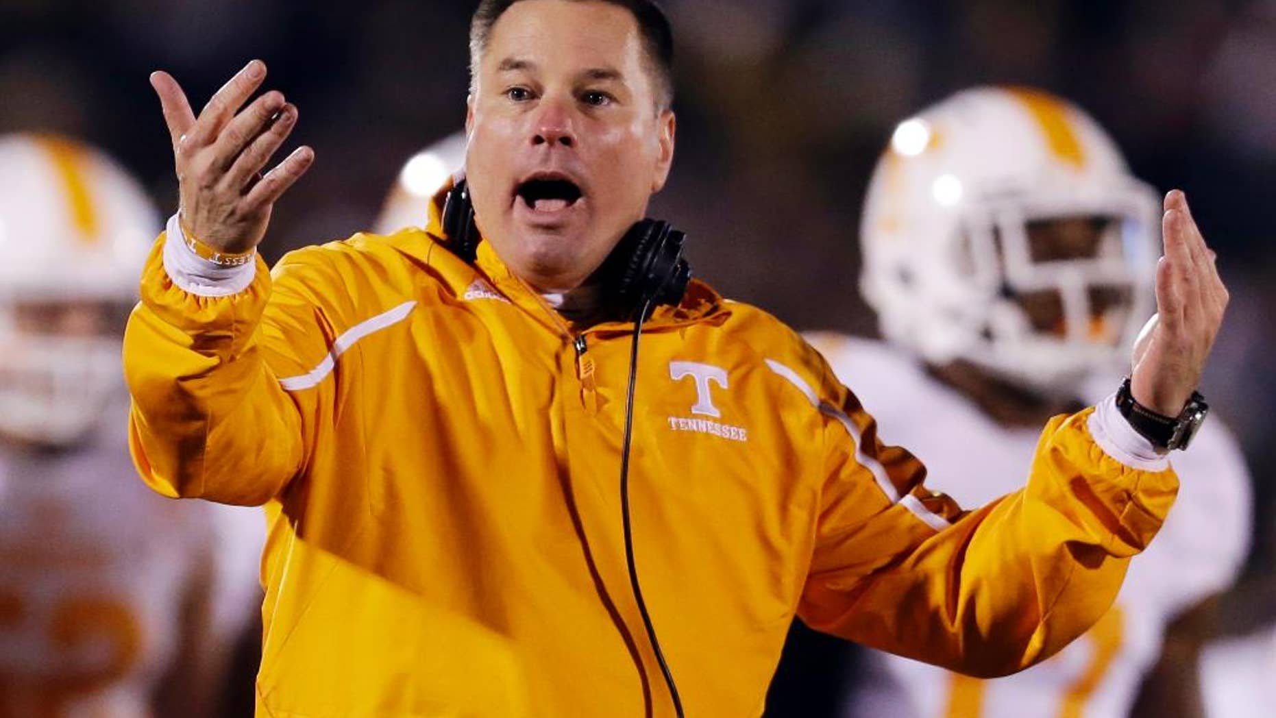 FILE - In this Nov. 2, 2013, file photo, Tennessee head coach Butch Jones yells on the sidelines during the first half of an NCAA college football game against Missouri in Columbia, Mo. Jones discusses the opening of a spring practice that features a four-way quarterback competition and the arrival of 14 early enrollees. The Volunteers hold their first spring workout Friday, March 7, 2014. (AP Photo/Jeff Roberson, File)