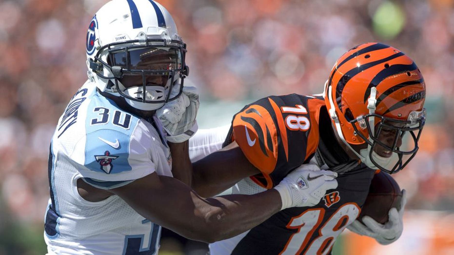 Sep 21, 2014; Cincinnati, OH, USA; Tennessee Titans cornerback Jason McCourty (30) tackles Cincinnati Bengals wide receiver A.J. Green (18) during the first half at Paul Brown Stadium. Mandatory Credit: Aaron Doster-USA TODAY Sports