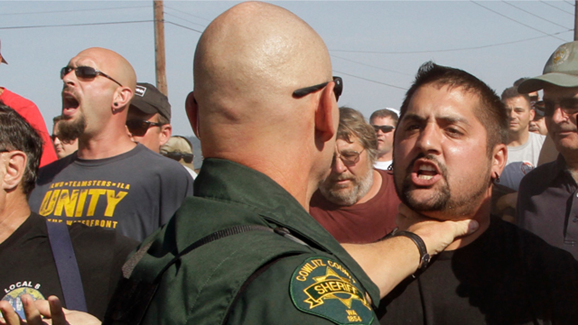 Sept. 7, 2011: A Cowlitz County Sheriff grabs a union worker by the throat as police move in on several hundred union workers blocking a grain train in Longview, Wash. Longshoremen blocked the train as part of an escalating dispute about labor at the EGT grain terminal at the Port of Longview.