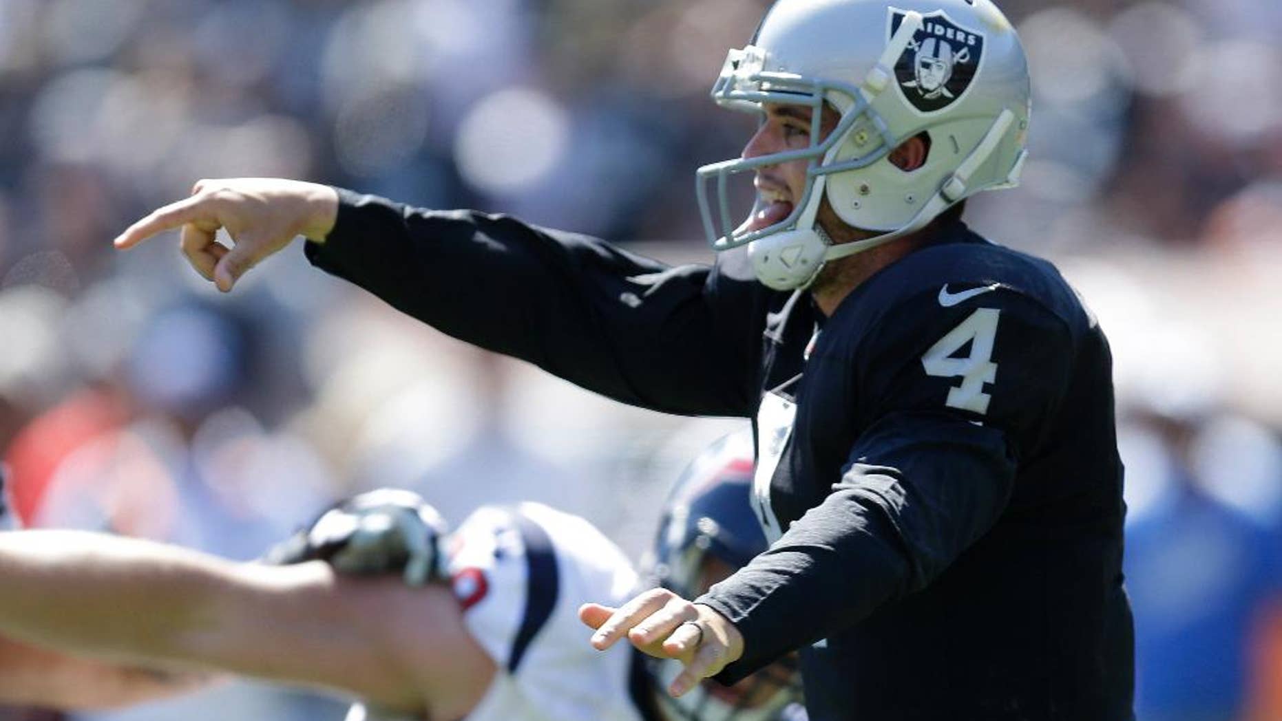 Houston Texans running back Arian Foster, left, carries the ball past Oakland Raiders outside linebacker Sio Moore in the first quarter of an NFL football game Sunday, Sept. 14, 2014, in Oakland, Calif. (AP Photo/Ben Margot)