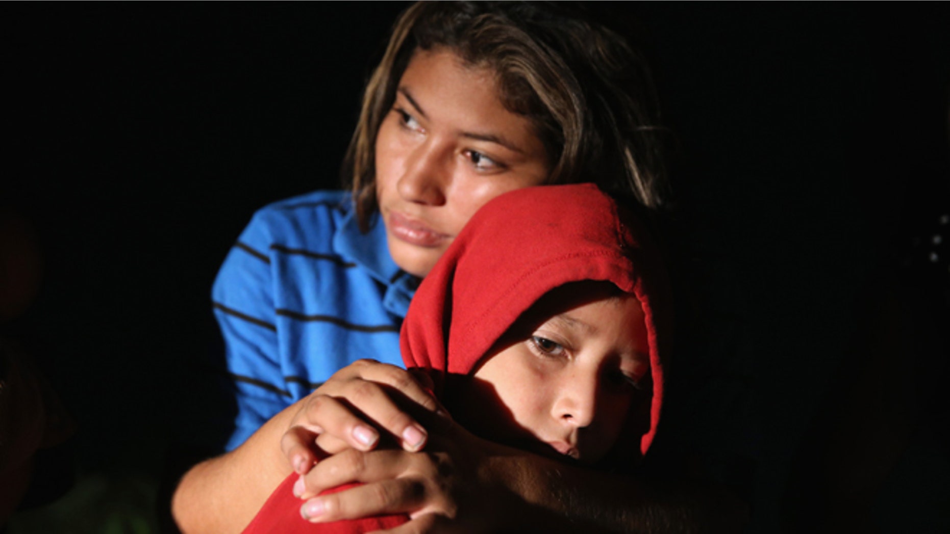 MISSION, TX - SEPTEMBER 08: Families of Central American immigrants, including Lorena Arriaga, 27, and her son Jason Ramirez, 7, from El Salvador, turn themselves in to U.S. Border Patrol agents after crossing the Rio Grande River from Mexico on September 8, 2014 to Mission, Texas. Although the numbers of such immigrant families and unaccompanied minors have decreased from a springtime high, thousands continue to cross in the border illegally into the United States. Texas' Rio Grande Valley sector is the busiest area for illegal border crossings, especially for Central Americans, into the U.S. (Photo by John Moore/Getty Images)