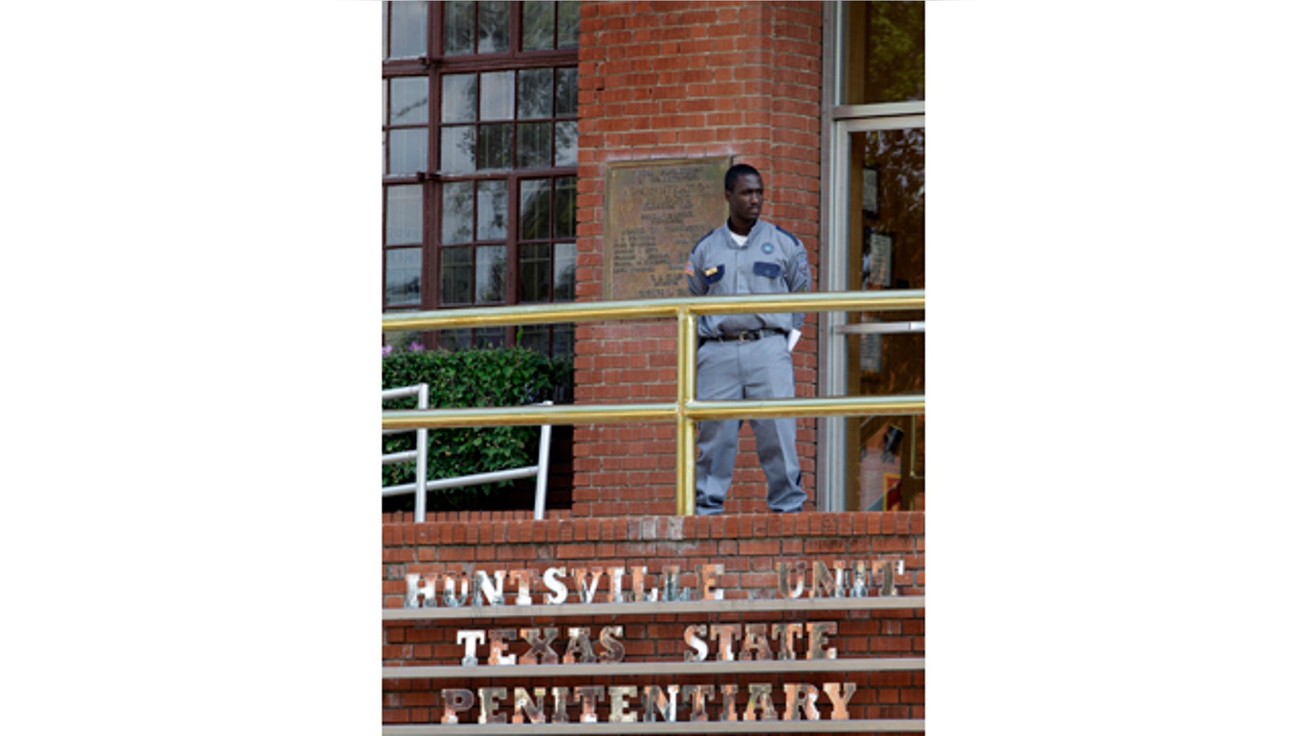 FILE - In this Sept. 21, 2011, file photo, a corrections officer keeps watch outside the Texas Department of Criminal Justice Huntsville Unit in Huntsville, Texas. (AP Photo/David J. Phillip, File)