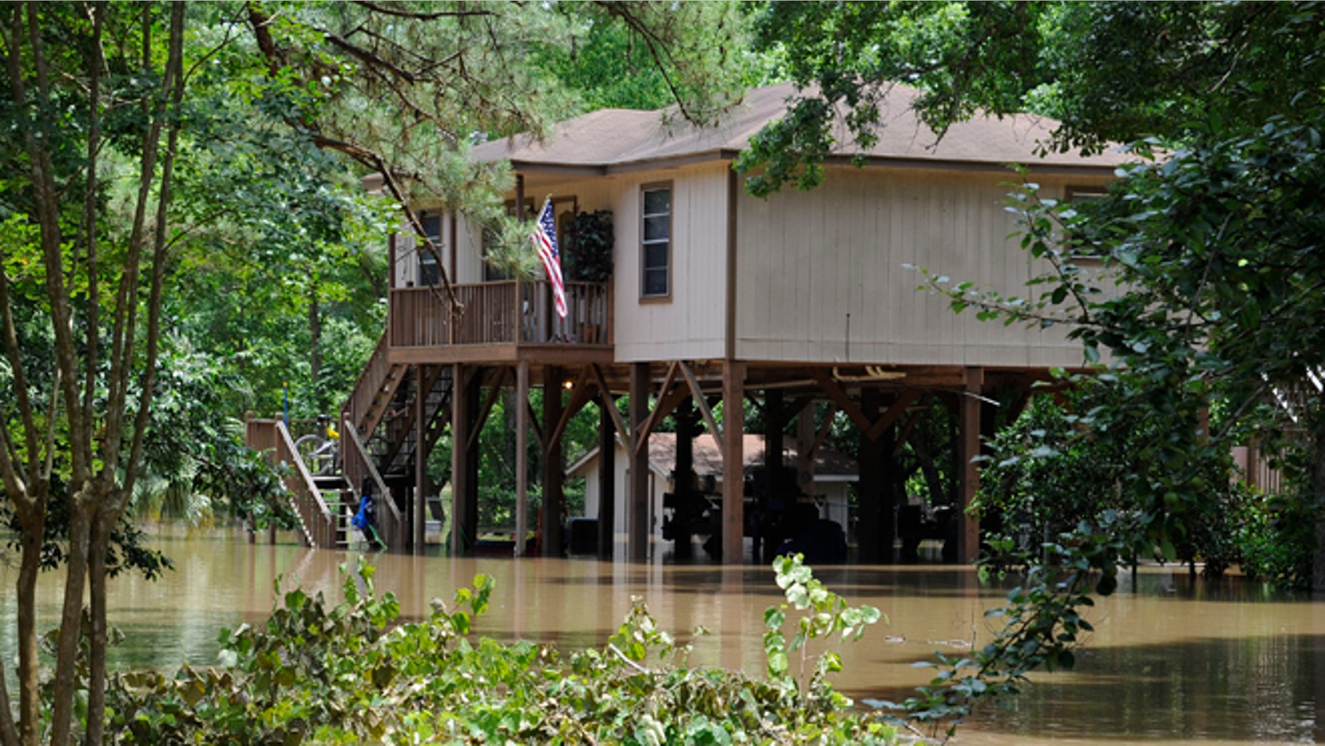 A house built on tall piers is surrounded by flood water from the San Jacinto River Thursday, May 28, 2015, in Kingwood, Texas. Although the deadly thunderstorms that lashed much of Texas have tapered off, many cities were still in danger of flooding Thursday as heavy rain from earlier in the week poured downstream, swelling rivers. (AP Photo/Pat Sullivan)