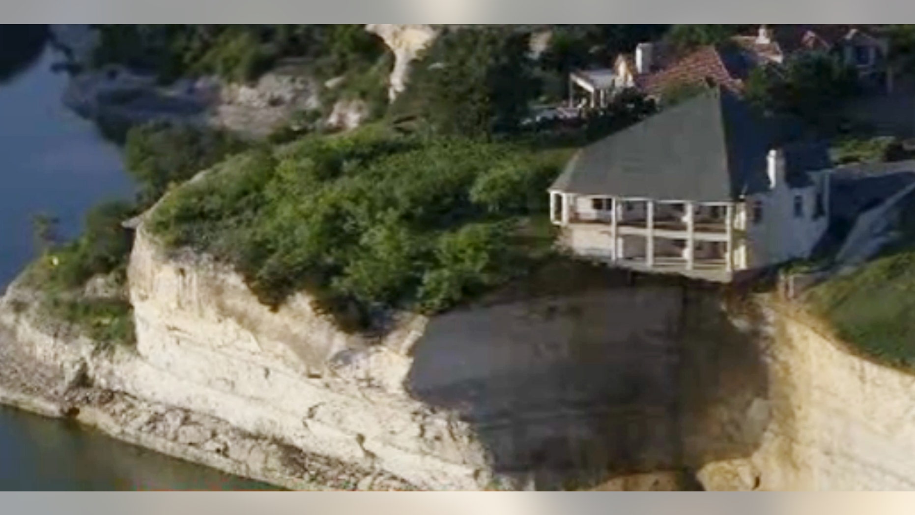 June 10, 2014: In this image taken from video provided by WFAA-TV, a luxury house teeters on a cliff about 75 feet above Lake Whitney in Whitney, Texas.