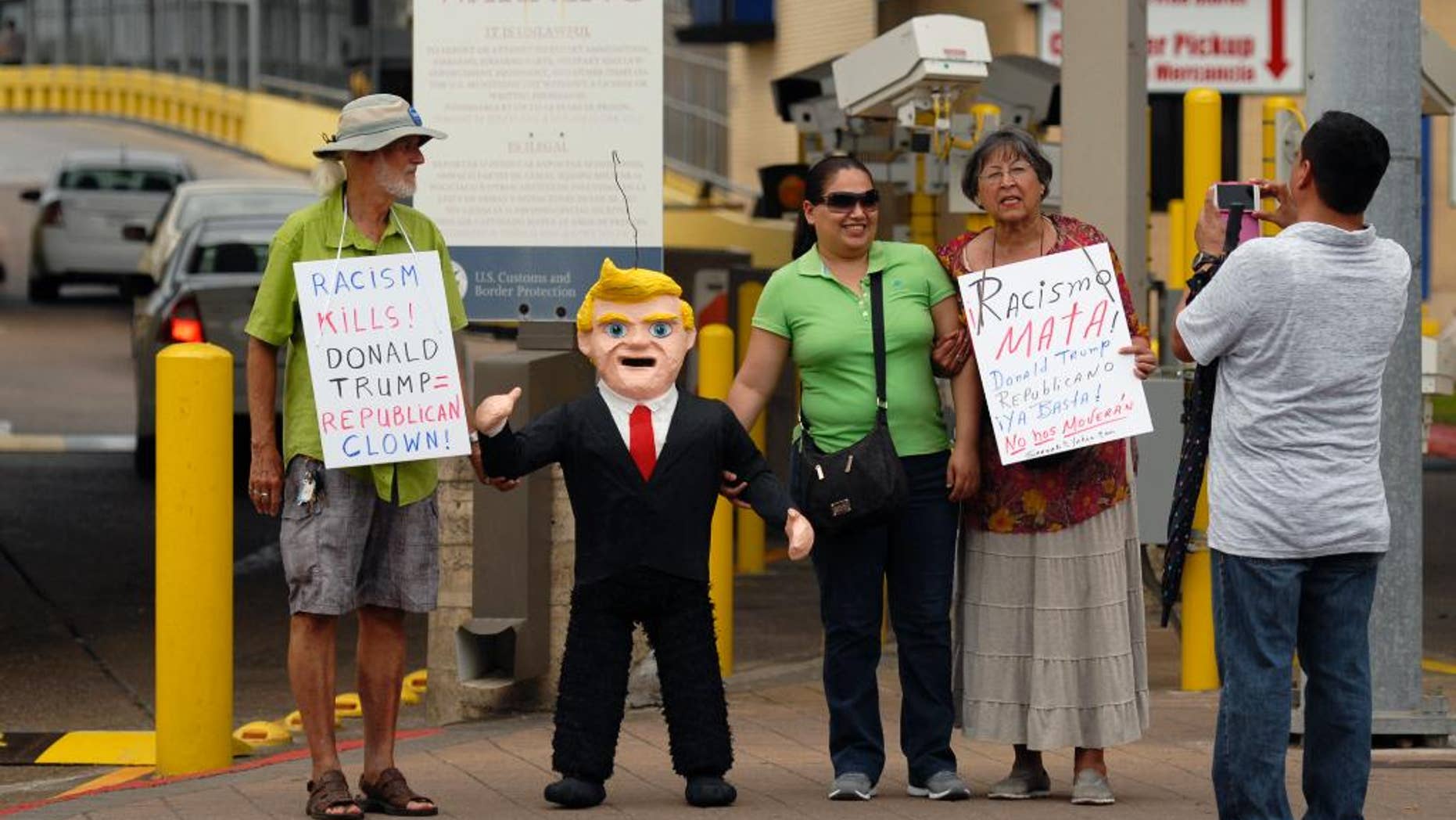 FILE - In this July 31, 2015 file photo, two women pose for a photo standing next to a pinata in the likeness of Donald Trump, during a protest against Trump and derogatory remarks he has made about Mexicans, in Brownsville, Texas. Mexico’s ambassador-designate to Washington, Miguel Basanez, sought to downplay Trump’s comments on Mexico, telling a Senate confirmation hearing on Friday, Aug. 28, 2015, that Trump is simply playing politics. (Brad Doherty/The Brownsville Herald via AP) MANDATORY CREDIT
