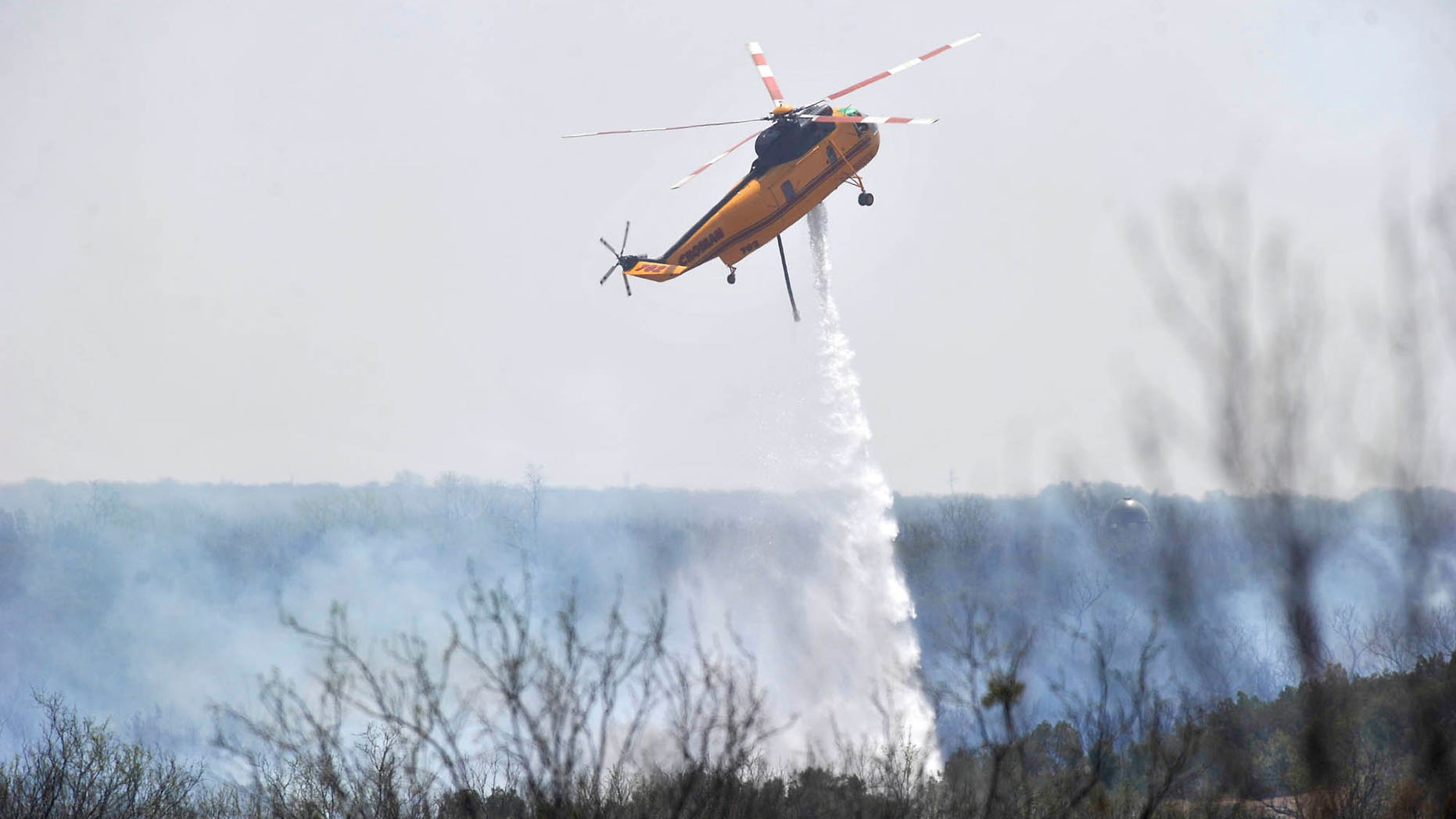 April 8: A Texas Forest Service helicopter drops water on a wildfire burning east of Highway 83 in Texas' northern Stonewall County. (AP Photo/The Abilene Reporter-News)