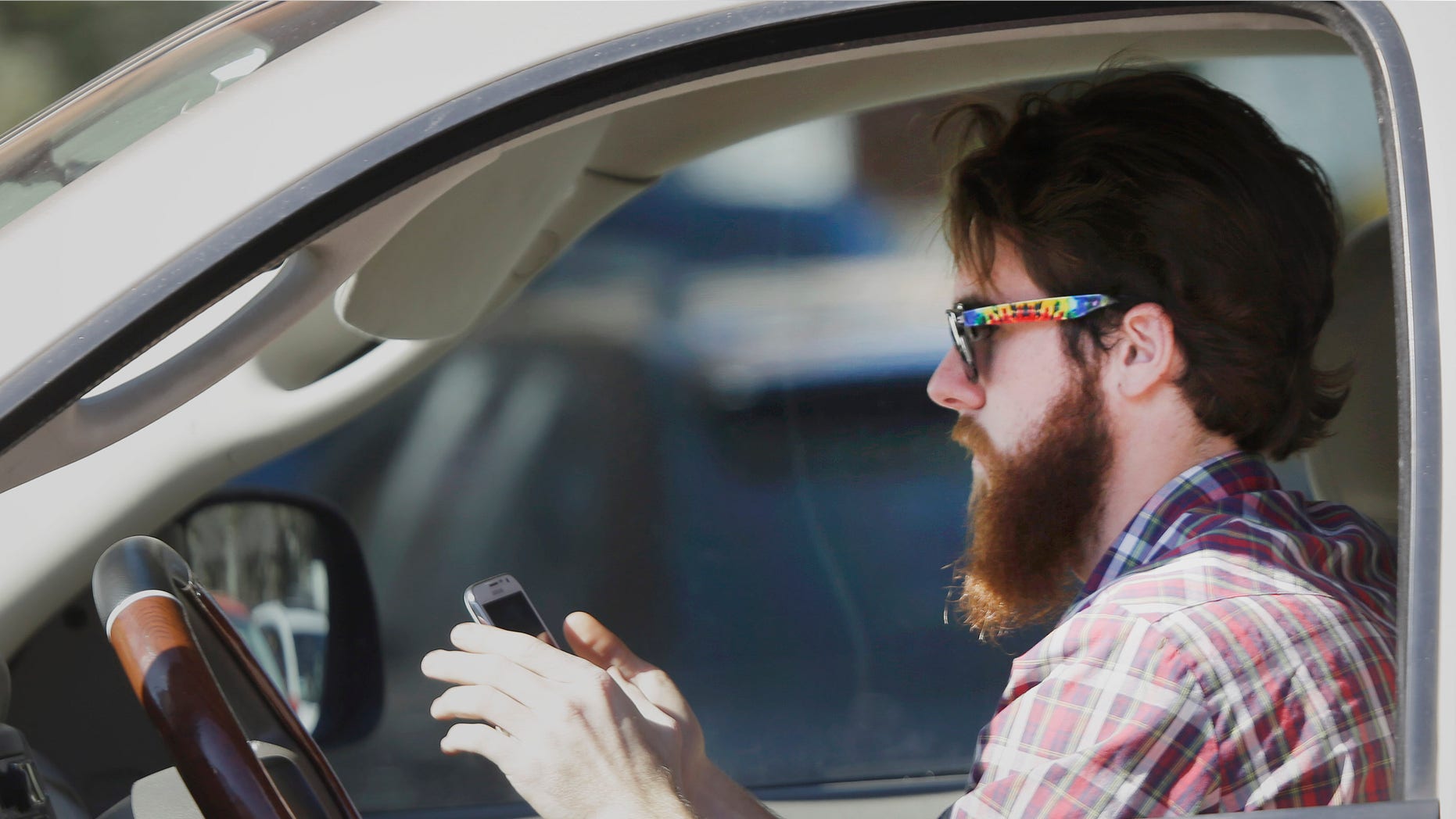 Feb. 26, 2013: A man uses his cell phone as he drives through traffic in Dallas.