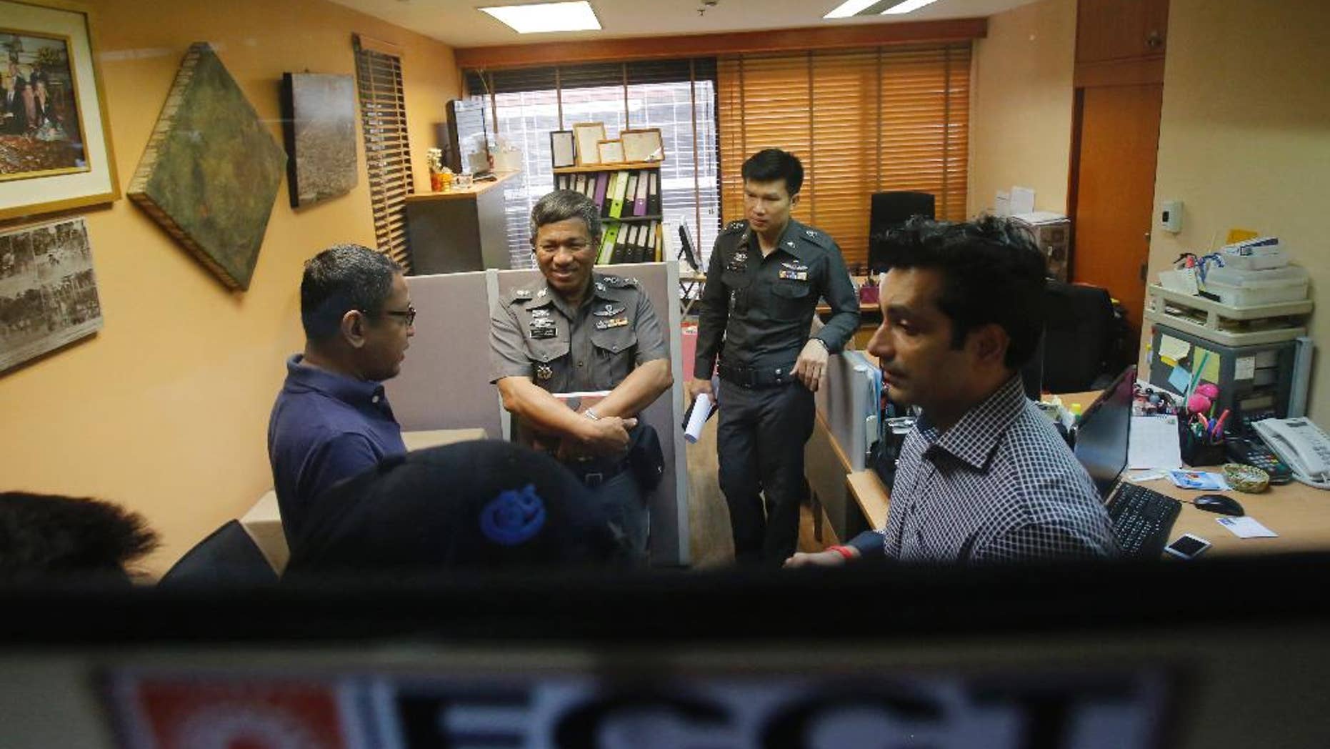 Sunai Phasuk, left, Human Rights Watch’s senior researcher in Asia, and Umesh Pandey, a board member of Foreign Correspondents of Thailand, right, talk to policemen at the Foreign Correspondents Club of Thailand in Bangkok, Thailand Friday, June 26, 2015. Thai authorities on Friday forced the human rights group to cancel the launch of its report on the Vietnamese government’s persecution of an ethnic minority, citing it could affect national security and bilateral relations. Thai police said in a statement Friday the scheduled event at the club could “have an impact on the country’s security or could affect the friendship and cooperation between Thailand and Vietnam.” (AP Photo/Sakchai Lalit)