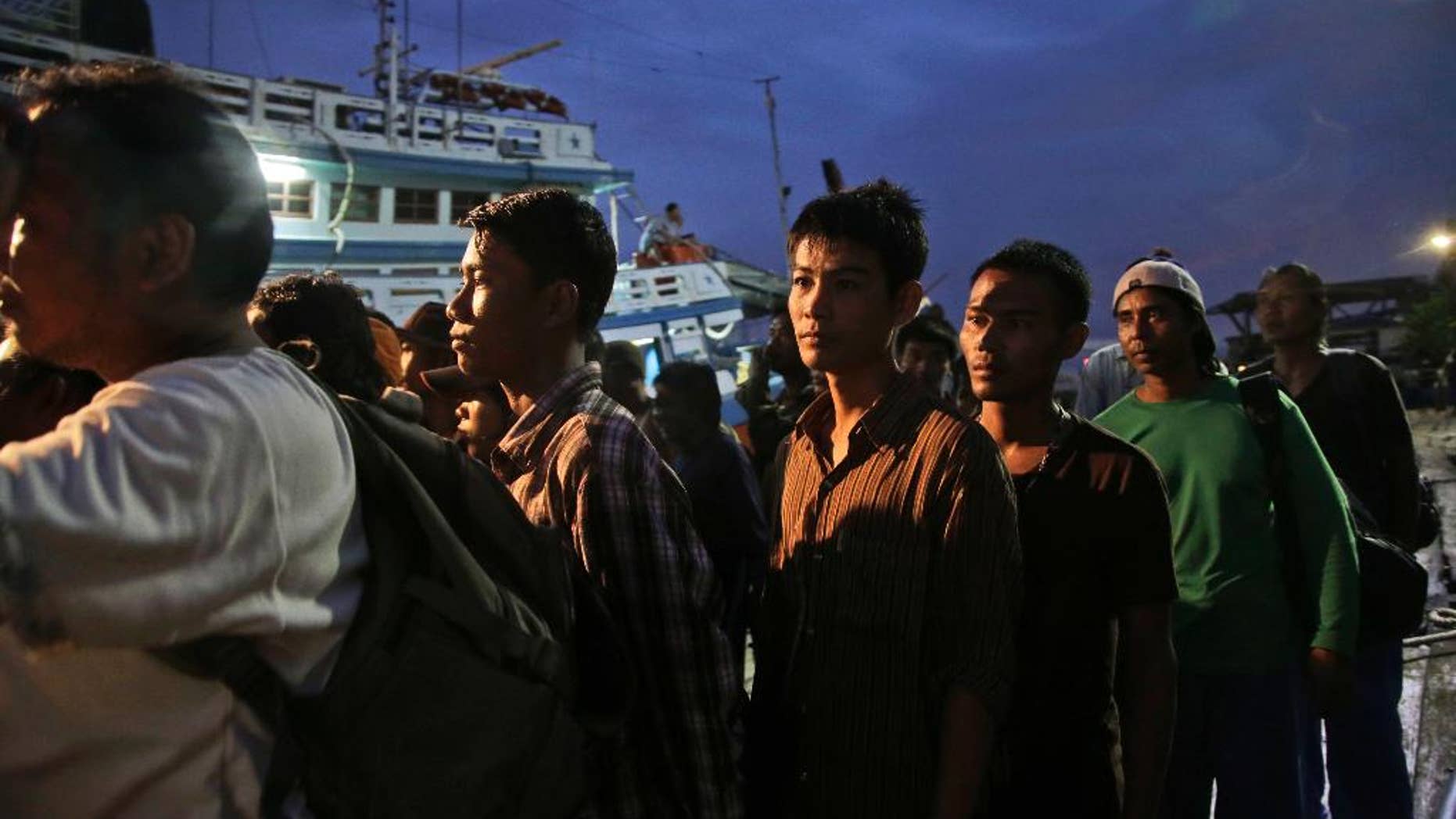 In this April 3, 2015, file photo, Burmese fishermen prepare to board a boat during a rescue operation in Benjina, Aru Islands, Indonesia. Thai police on Tuesday, Nov. 10, 2015, announced the arrest of a man they said tricked more than 100 men into working for low pay on illegal fishing boats in Indonesia, part of the government’s effort to show that it is cracking down on an industry that has been rife with human trafficking and labor abuses. (AP Photo/Dita Alangkara, File)