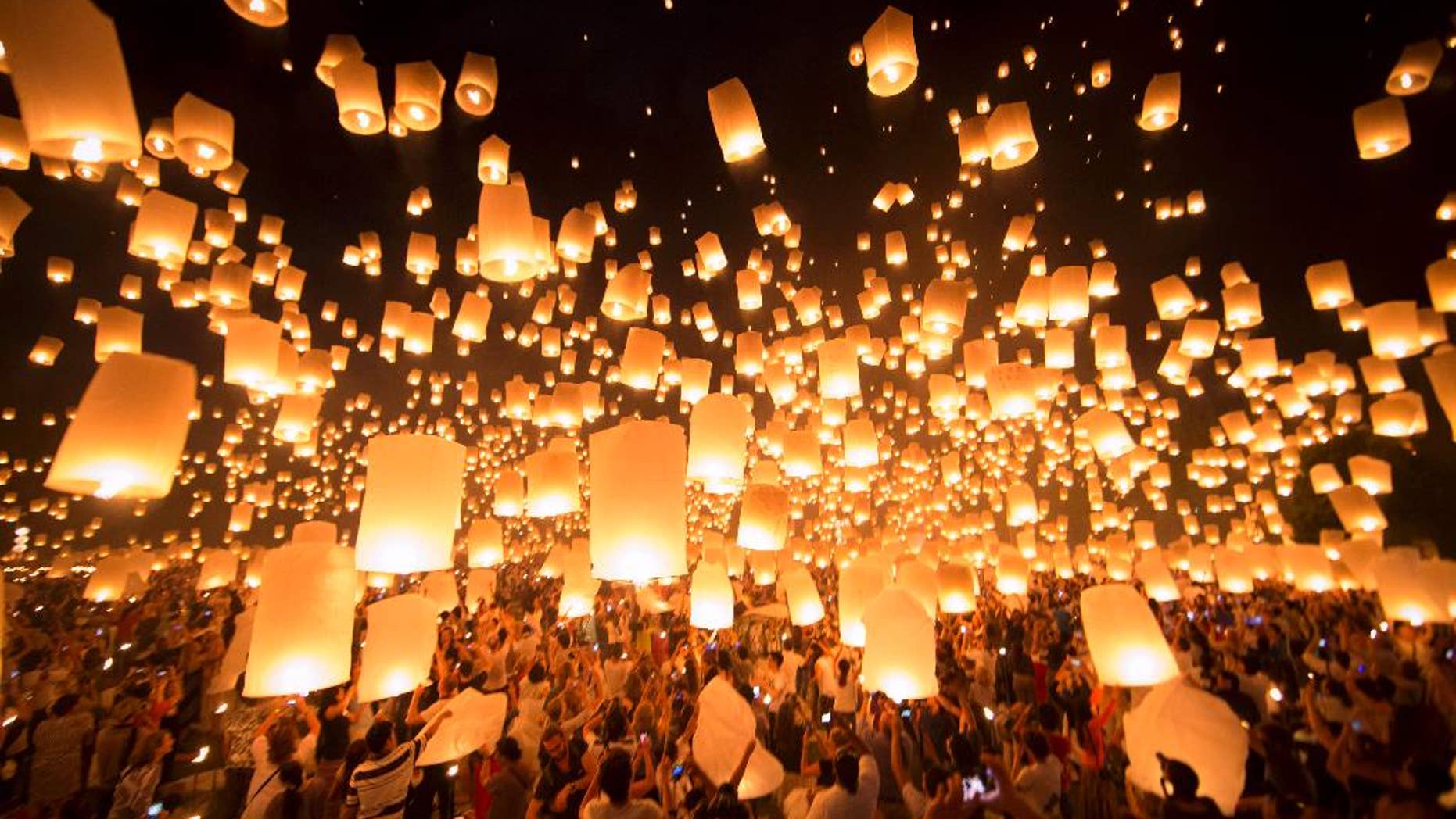 FILE - Thousands of paper-made balloons, powered by burning oil, rise into the evening sky in Chiang Mai province, some 580 kilometers (360 miles) north of Bangkok during the Loy Krathong Festival, Saturday, Nov. 16, 2013. Revelers in northern Thailand have been asked not to launch lanterns into the sky near airports to avoid airborne accidents during a popular festival later this week, airport officials said Tuesday. (AP Photo/Vincent Thian, File)