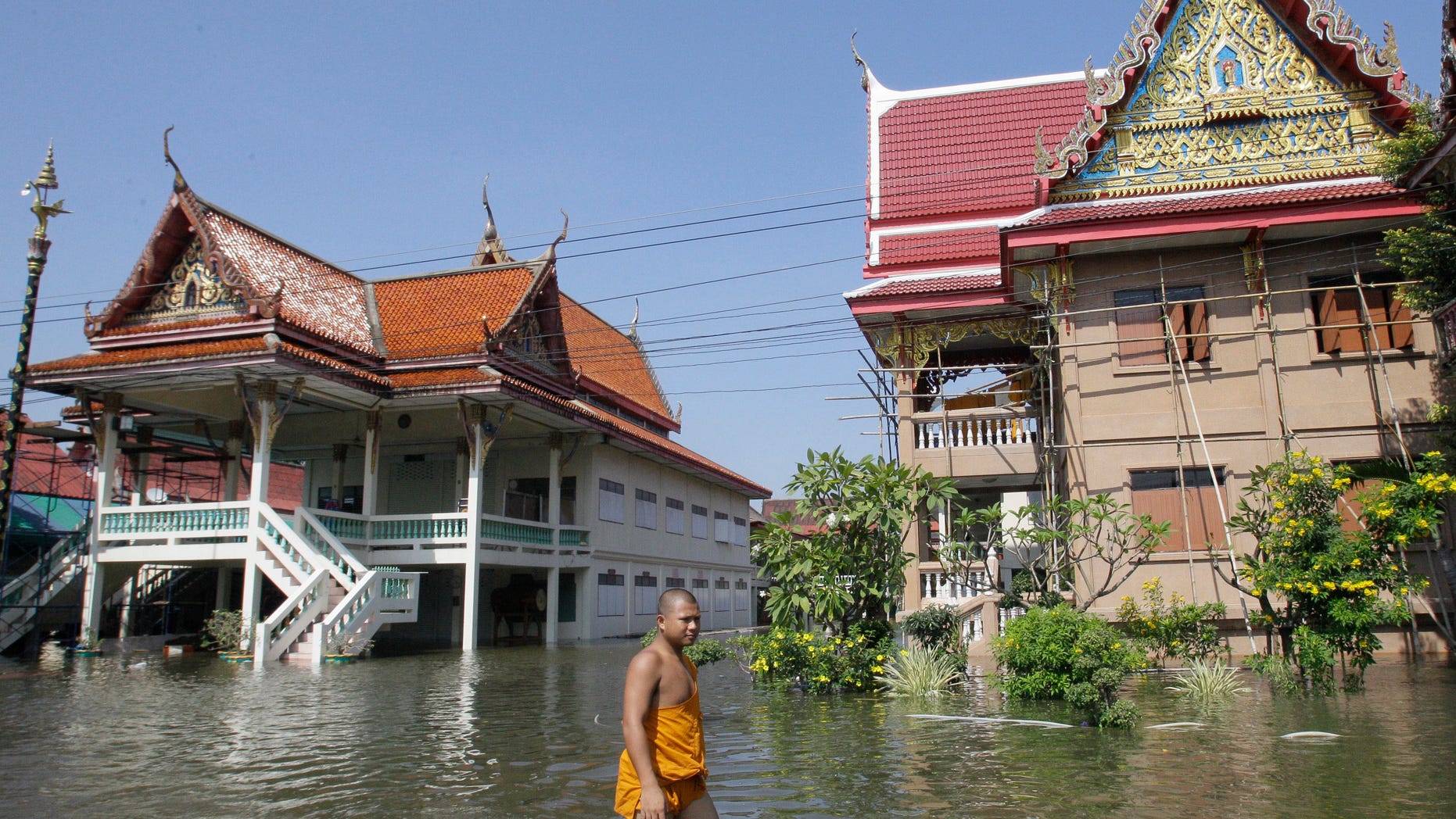 Oct. 19, 2011: Thai Buddhist monk wades through a flooded street at Ban Kadee temple in Phatum Thani province, north of Bangkok ,Thailand.