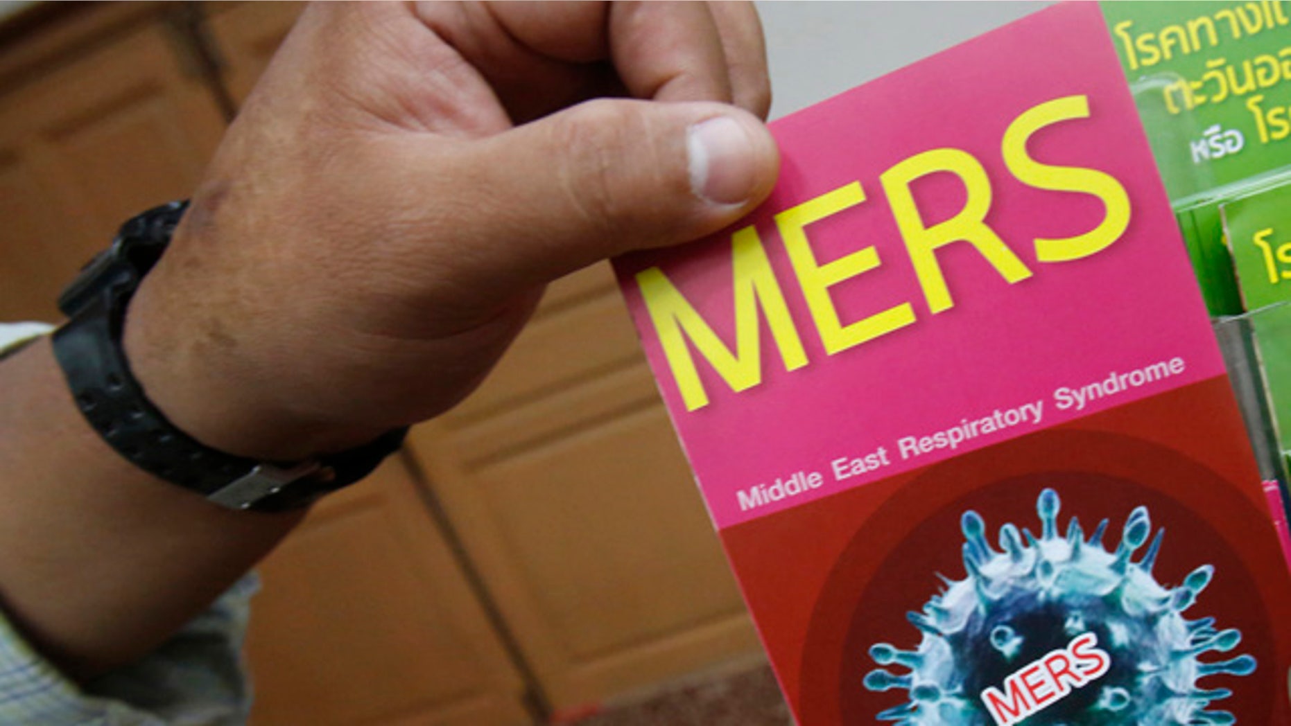 June 18, 2015: A Thai officer takes a flyer after Public Health Minister Rajata Rajatanavin's press conference in Bangkok. Thailand says it has confirmed its first known case of the deadly MERS virus, a man who arrived from a Middle Eastern country for treatment of a heart condition. (AP Photo/Sakchai Lalit)