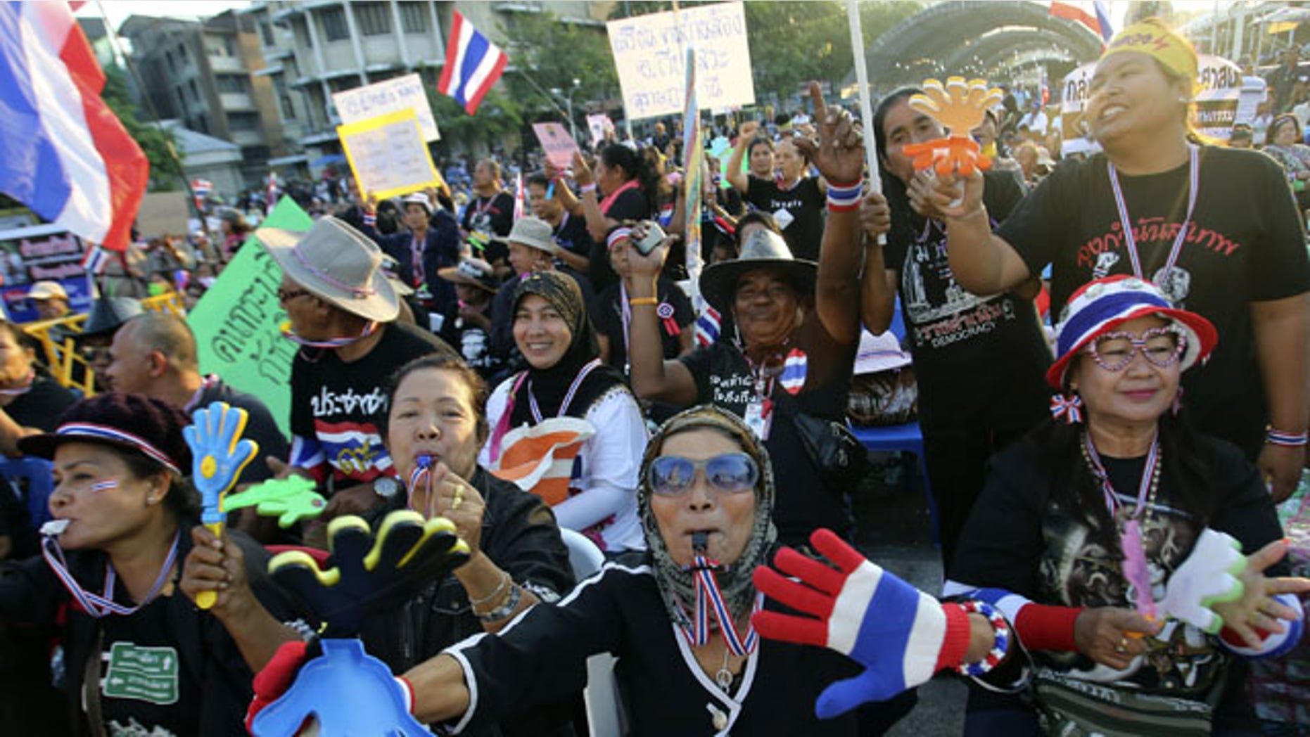 December 1, 2013: Anti-government protesters wave Thai national flags and clapping tools during rally at the Democracy Monument in Bangkok, Thailand. Aggressive political protests in the Thai capital turned violent late Saturday with at least one man killed and several wounded by gunshots in street fighting between supporters and opponents of Prime Minister Yingluck Shinawatra.(AP Photo)