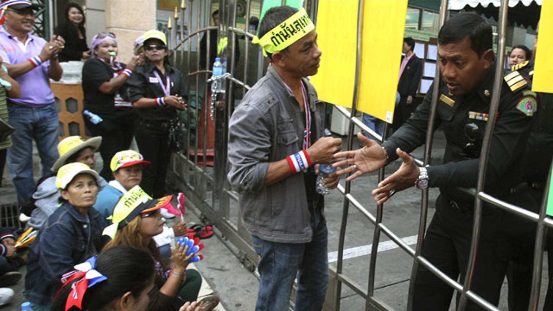 January 26, 2014: Anti-government protester talk to an election officer while gathering in front of a polling station in Patumwan district during a rally in Bangkok, Thailand. (AP Photo/Sakchai Lalit)